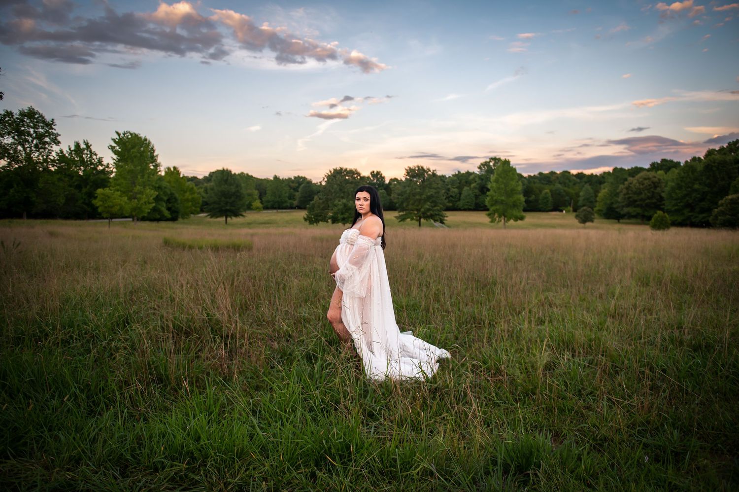 Romantic sunset wedding photos in rustic field with soft golden hour lighting.