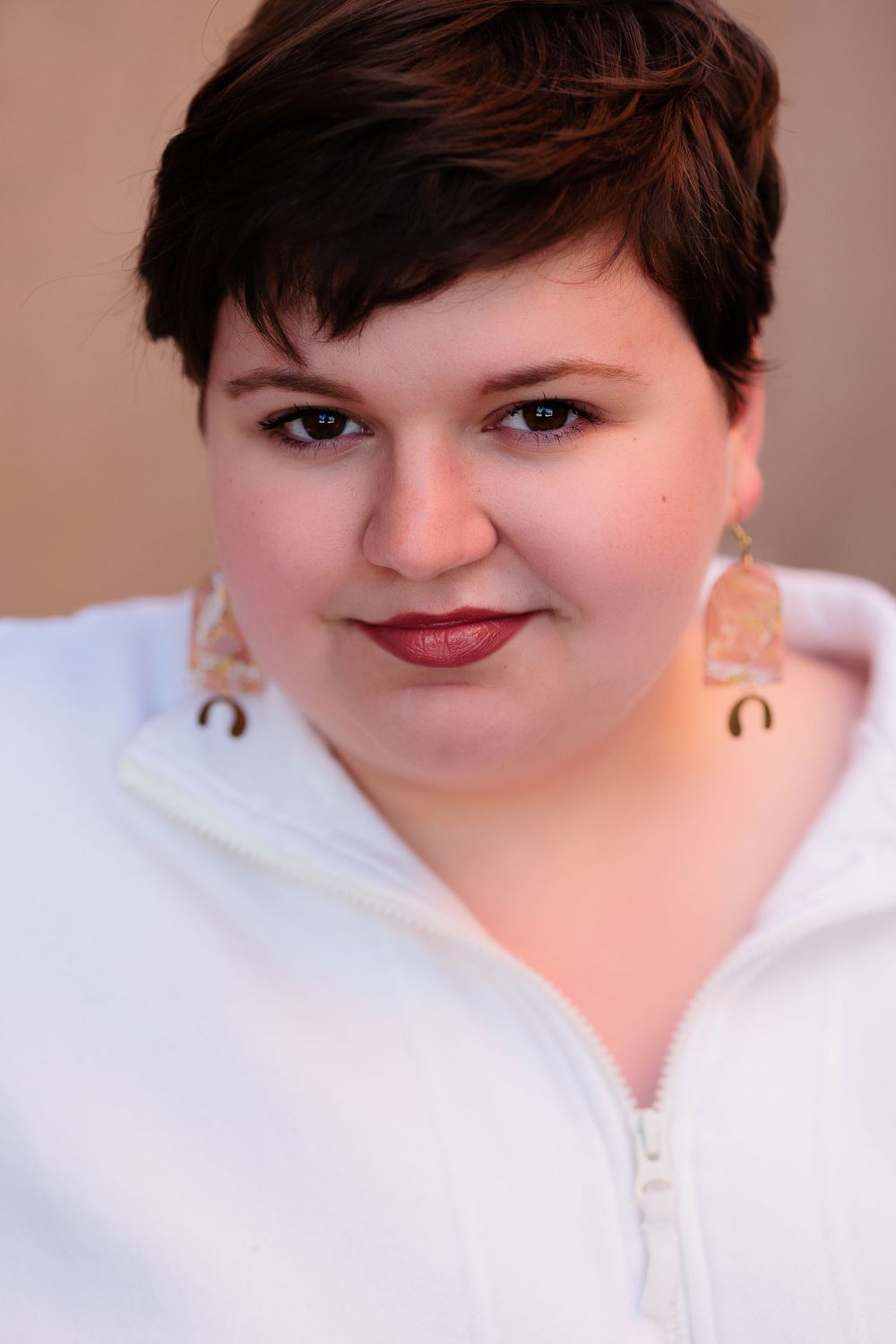 Studio portraits showing different angles and expressions in white top.