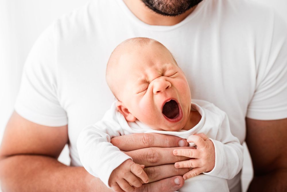 father holding his baby in all-white setting in Hereford