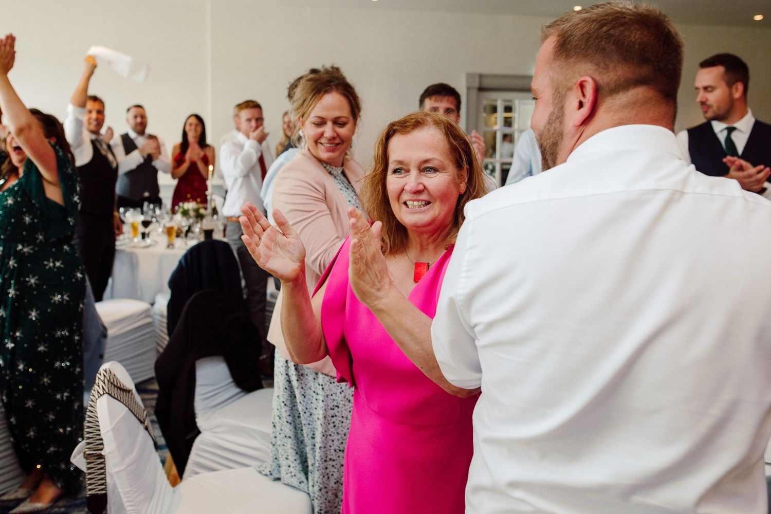 Wedding guests dancing and celebrating together at a lively reception.