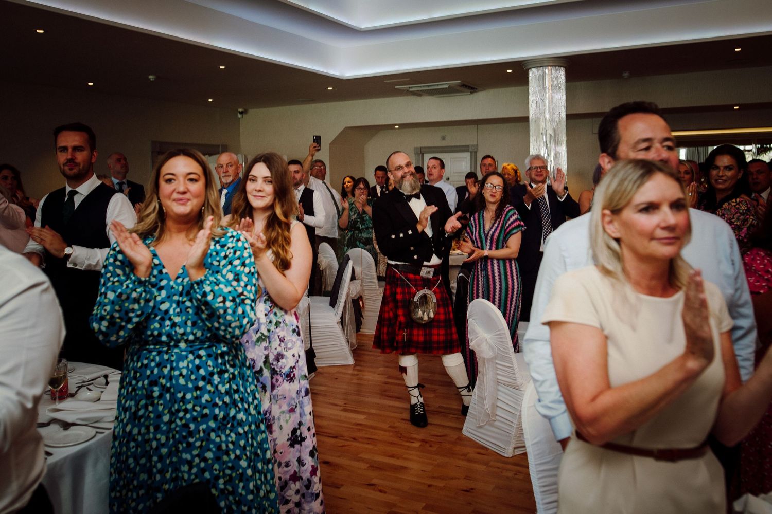 Wedding reception guests dancing and celebrating in an elegant ballroom.
