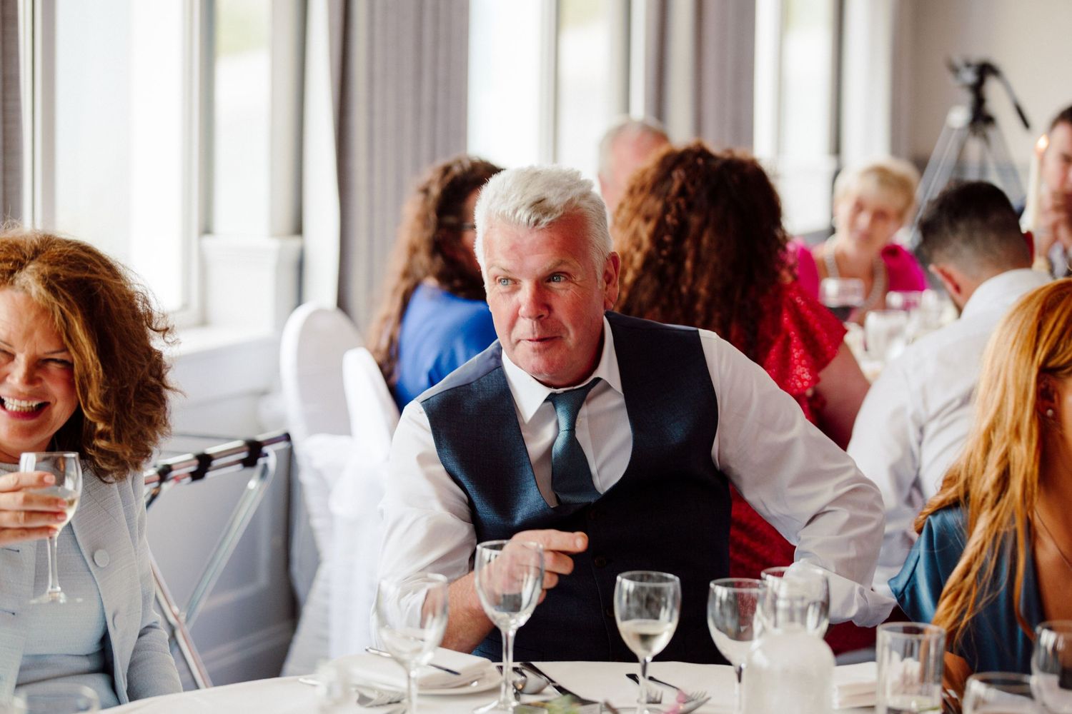 Guest enjoying dinner at an elegant wedding reception with wine glasses on table.