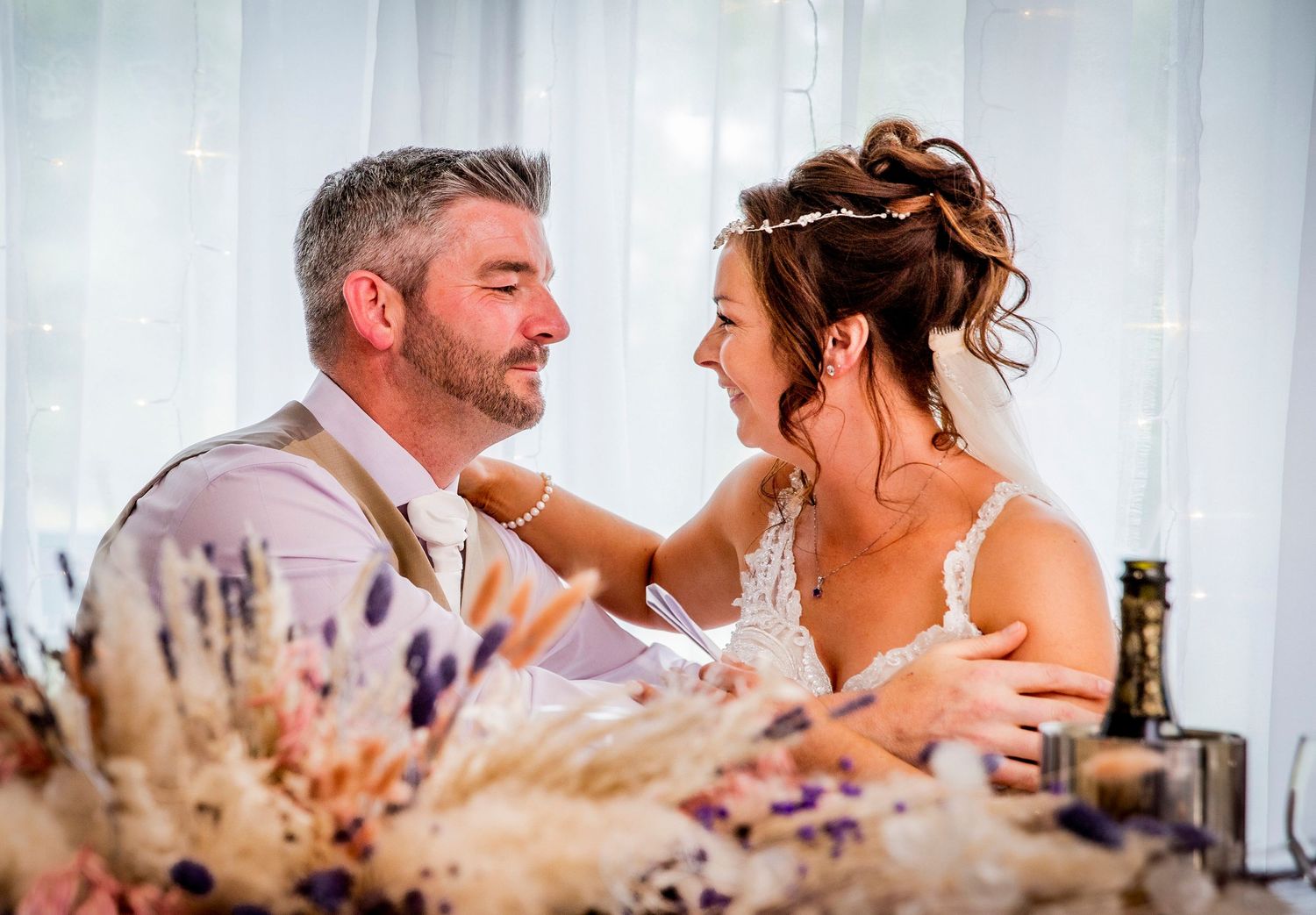 Intimate wedding reception moments captured with decorative pampas grass in foreground.