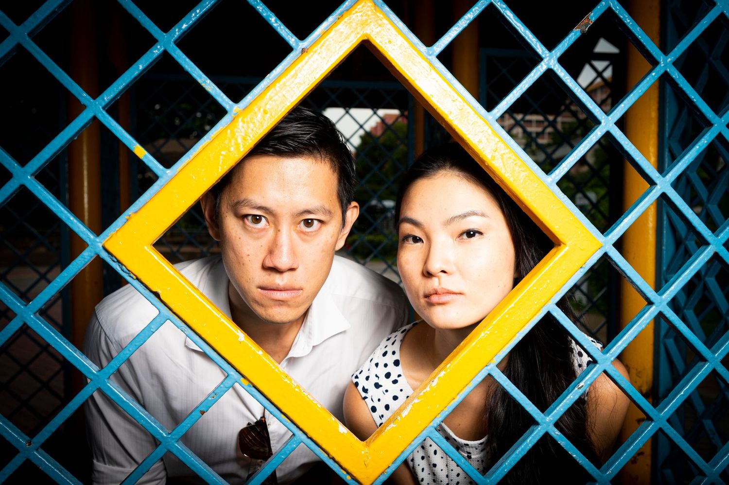 A couple poses inside a yellow decorative frame against a blue geometric background. Scotch Plains Photographer, portrait photography.