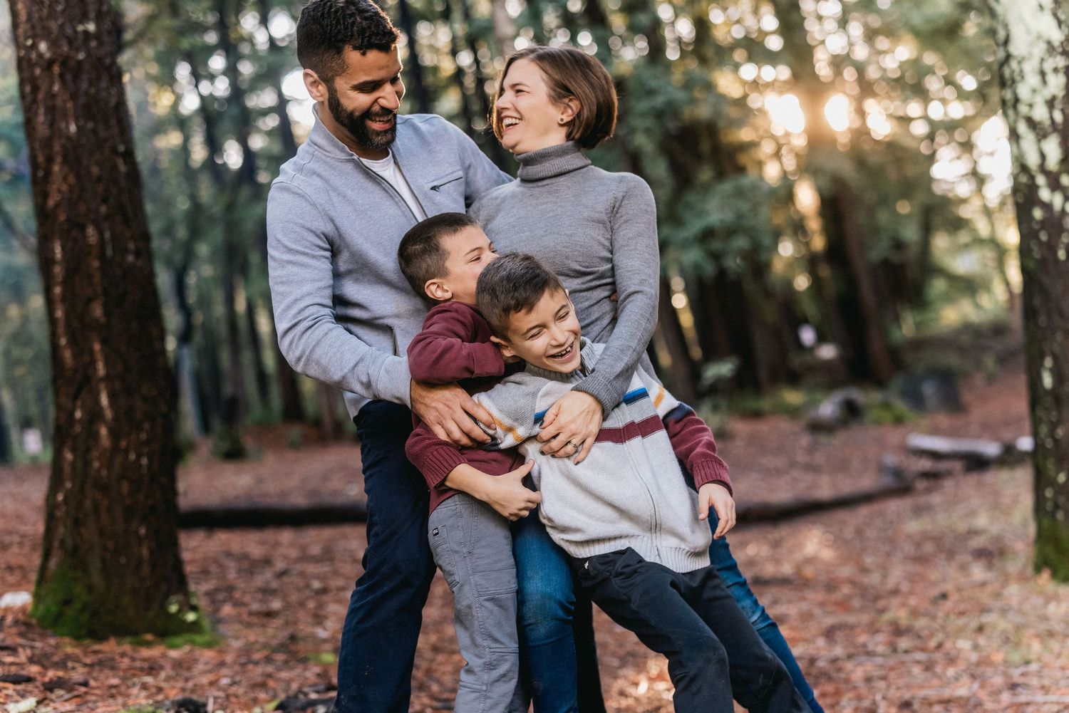 A tender family moment shared on an autumn forest trail covered with fallen leaves.