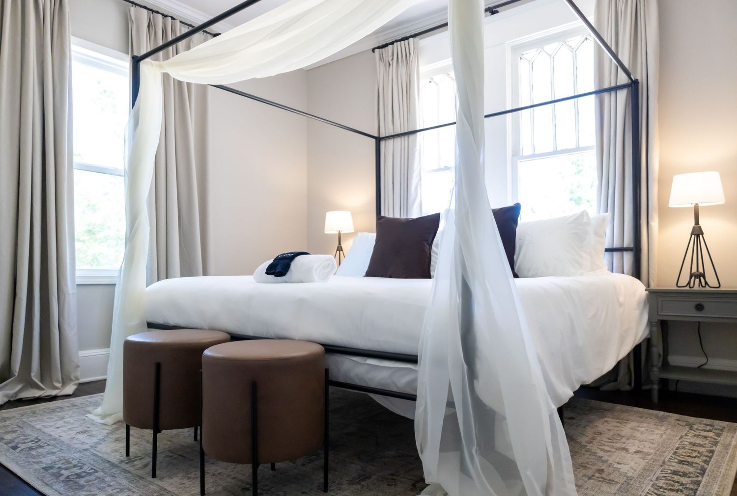 Cozy bed with elegant rails positioned above, adorned with flowing curtains.