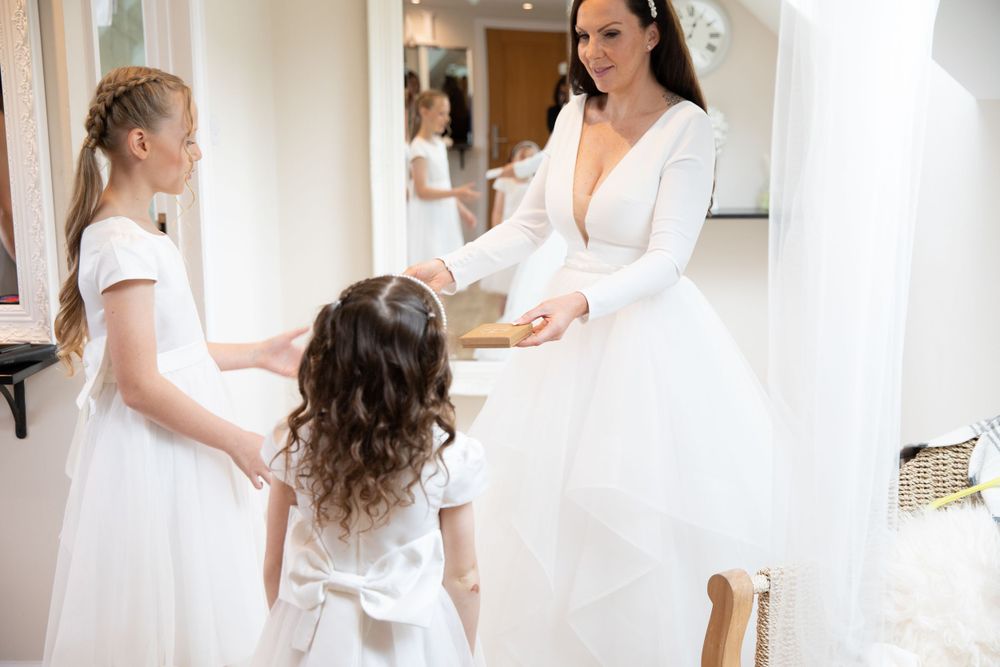 Wedding preparation scene with white dresses and natural lighting from skylight.
