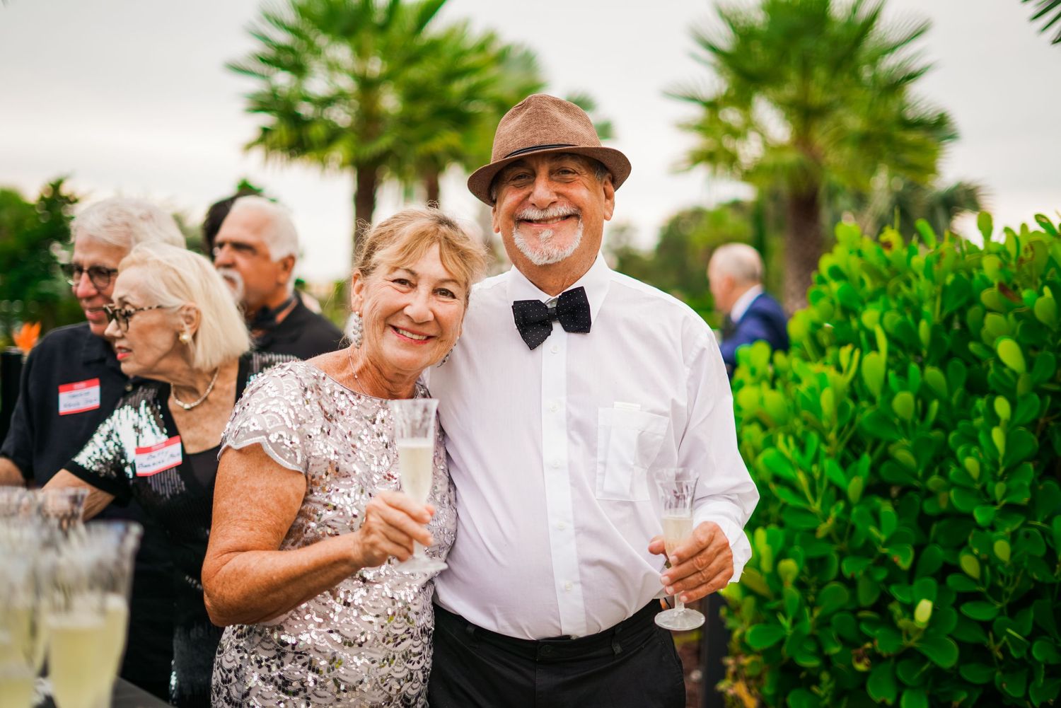 a happy couple smiling for a photo while attending a formal party