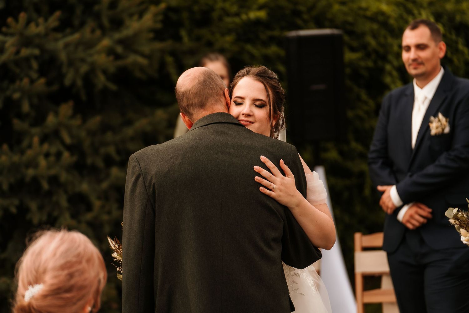 Emotional moment at outdoor garden wedding ceremony as couple embraces.