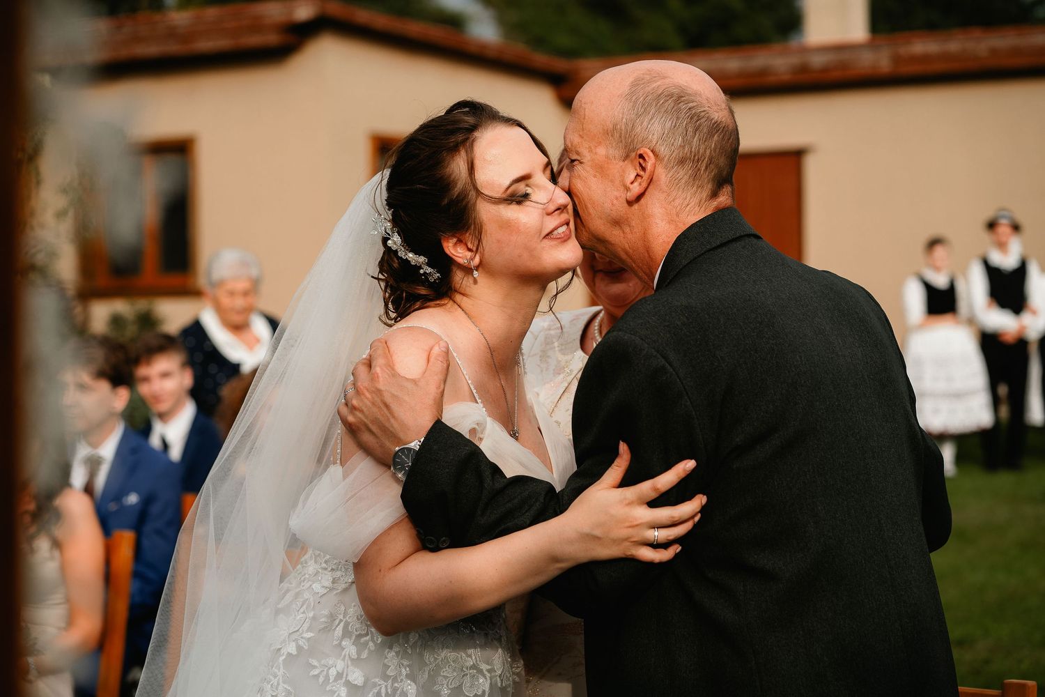 A tender moment between a bride and a guest during an outdoor wedding reception.