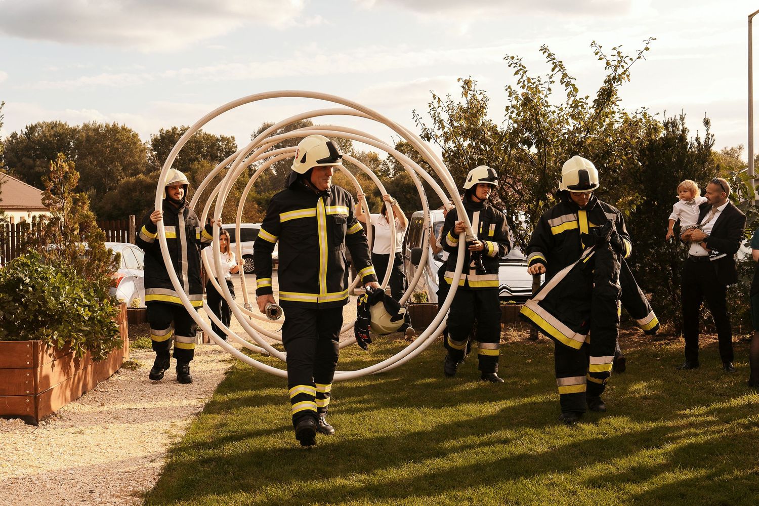 Firefighters perform with illuminated circular props during an outdoor evening celebration.