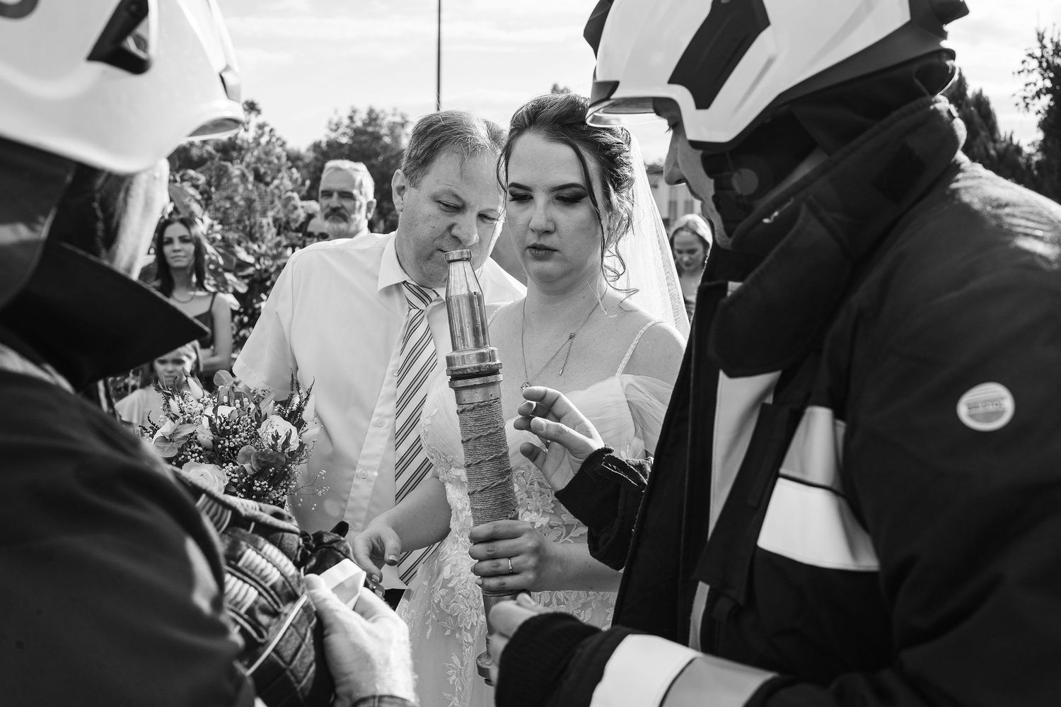 Firefighters examine equipment during an outdoor wedding ceremony.