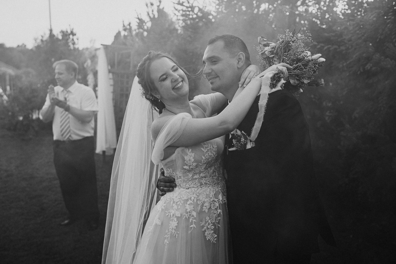 A joyful black and white moment captured during an outdoor wedding celebration.