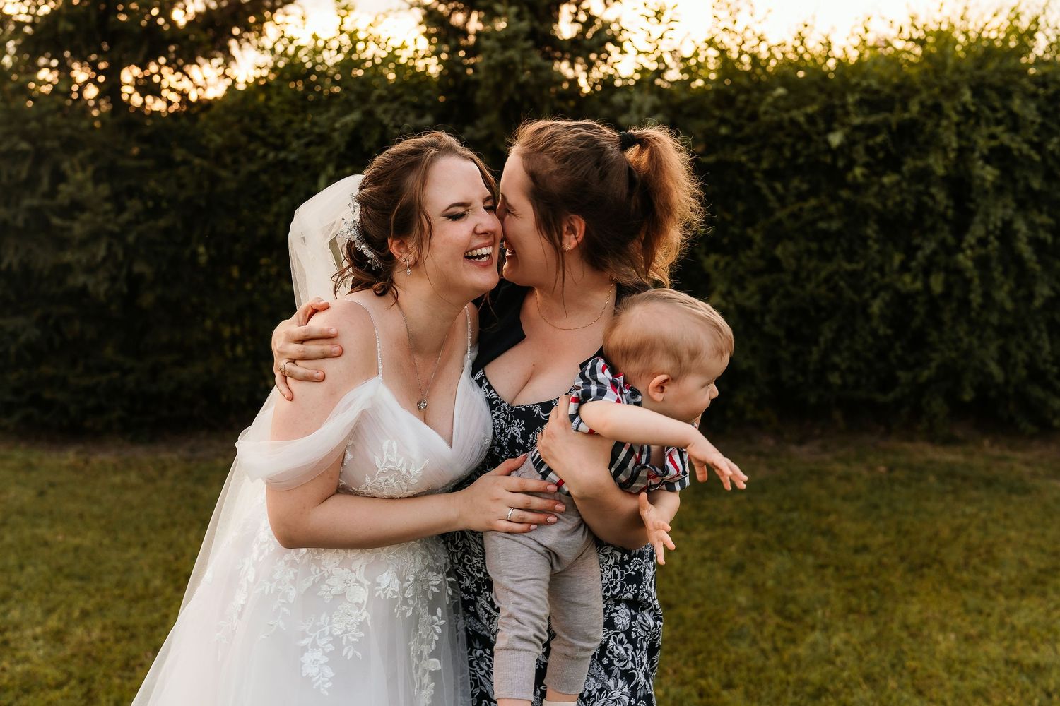 A tender moment shared between wedding guests on a sunny outdoor day.