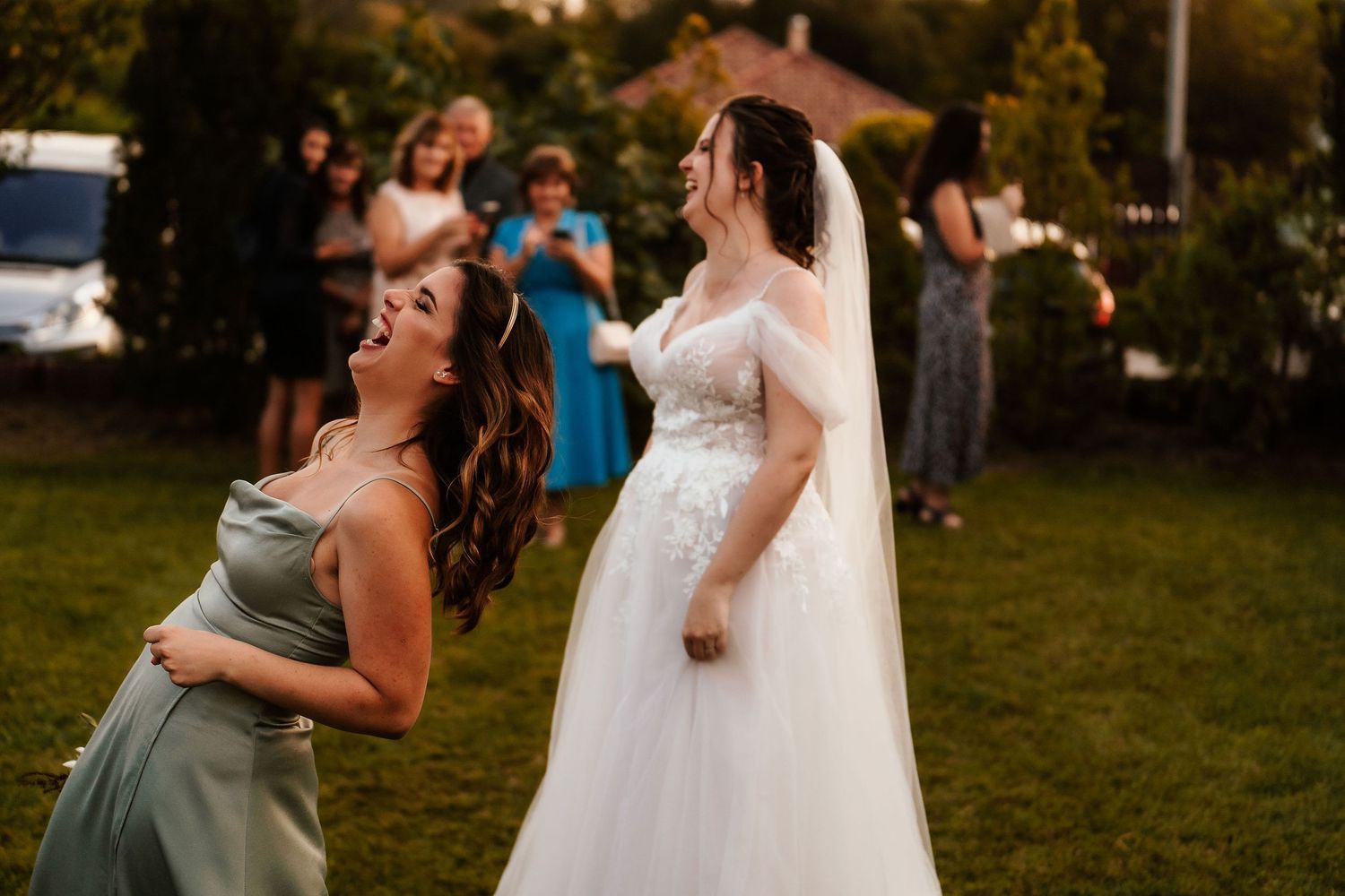 Wedding guests share a joyful dancing moment during an outdoor celebration.