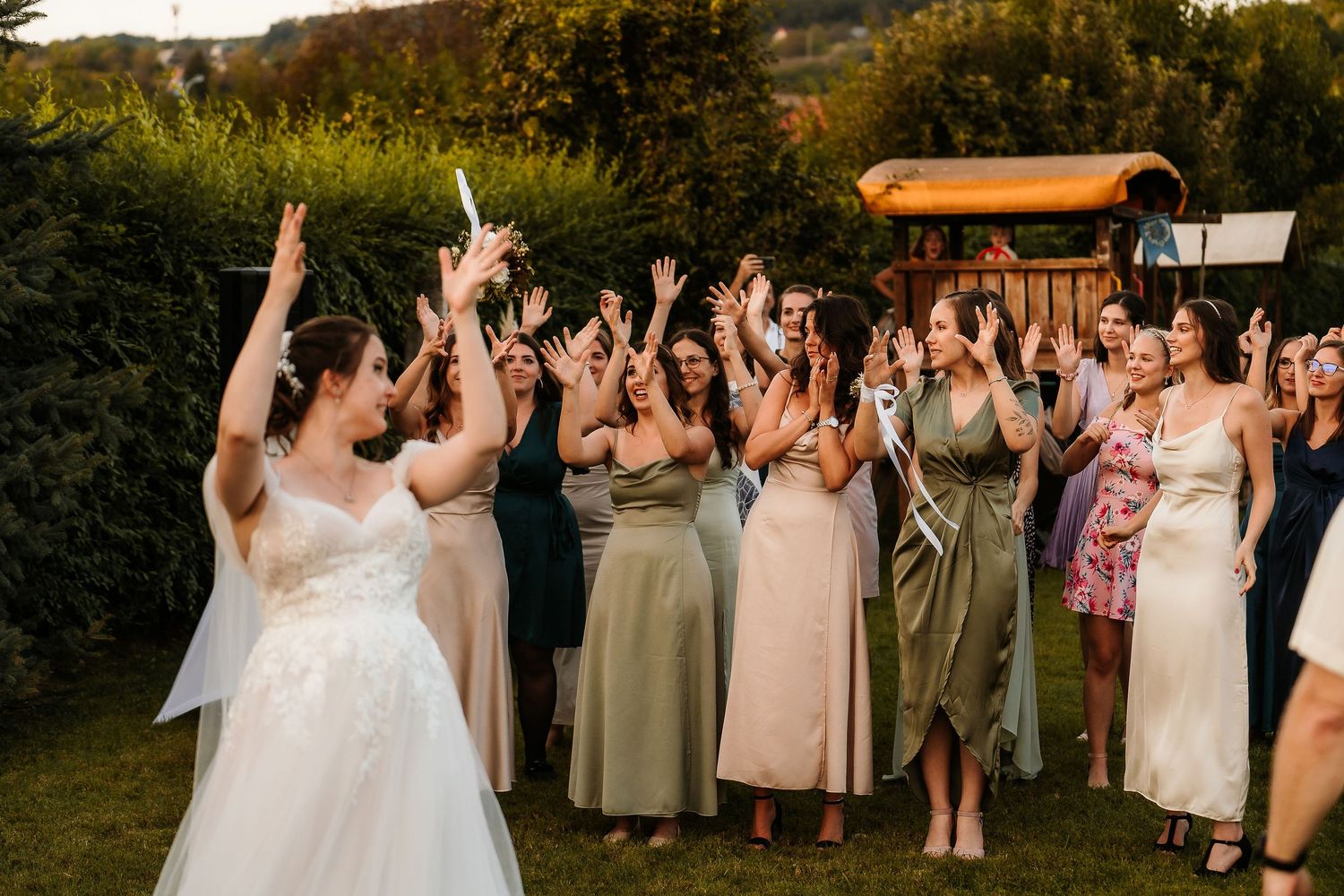 Celebration moment as wedding guests cheer with raised arms at an outdoor reception.