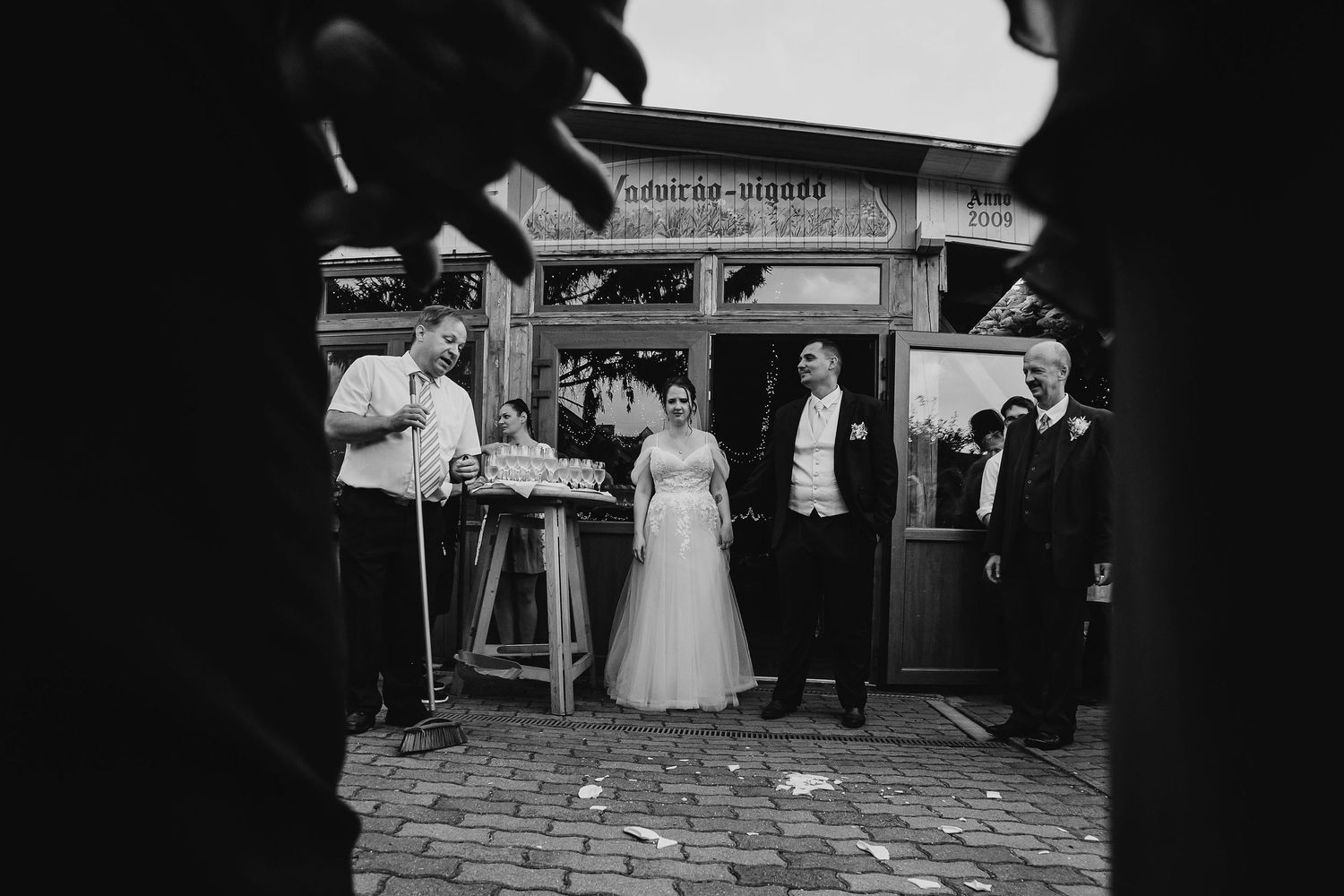 Black and white photo of wedding celebration at vintage storefront.