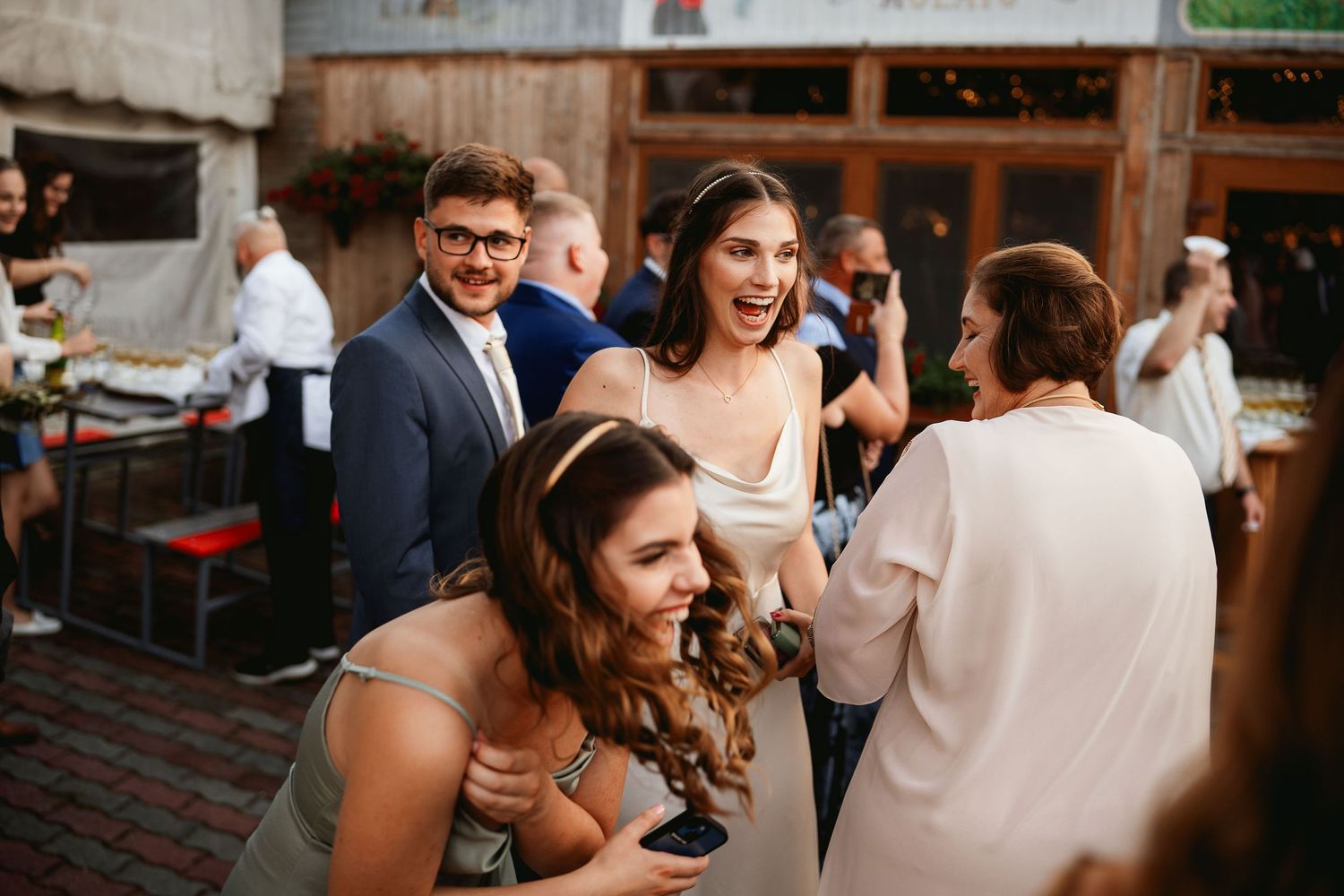 Lively wedding reception with guests laughing and celebrating.