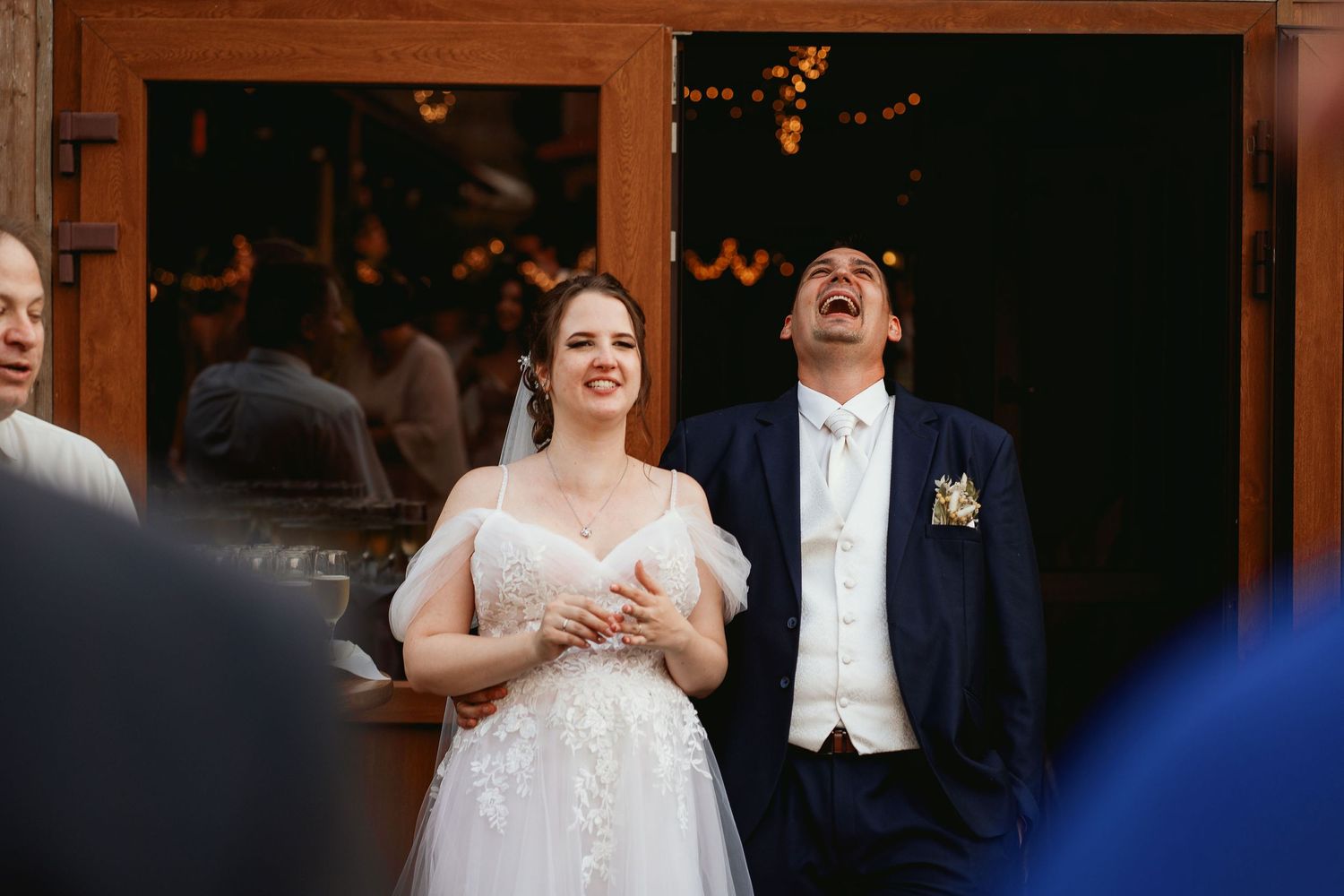 Wedding couple sharing joyful moment outside venue entrance.