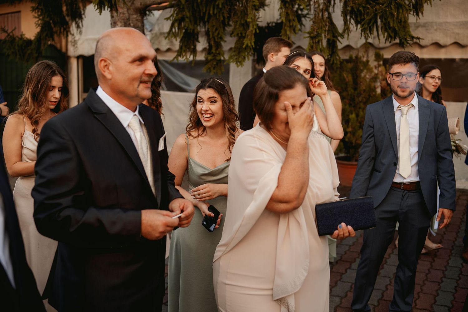 Candid moment at outdoor wedding reception with guests interacting.