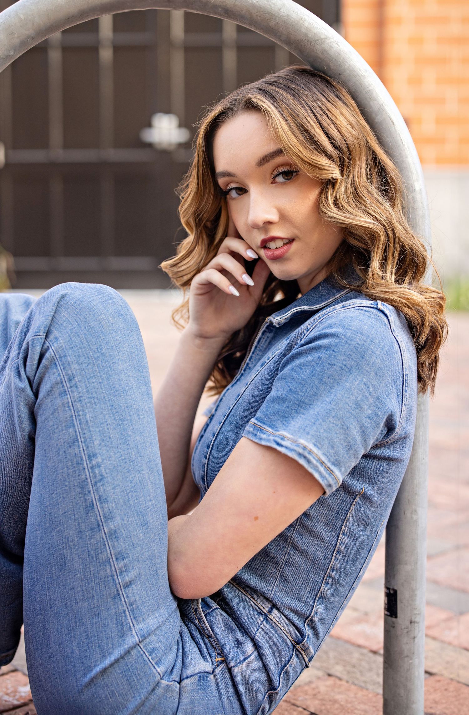 Casual portrait showcasing denim fashion against an urban backdrop with warm lighting.