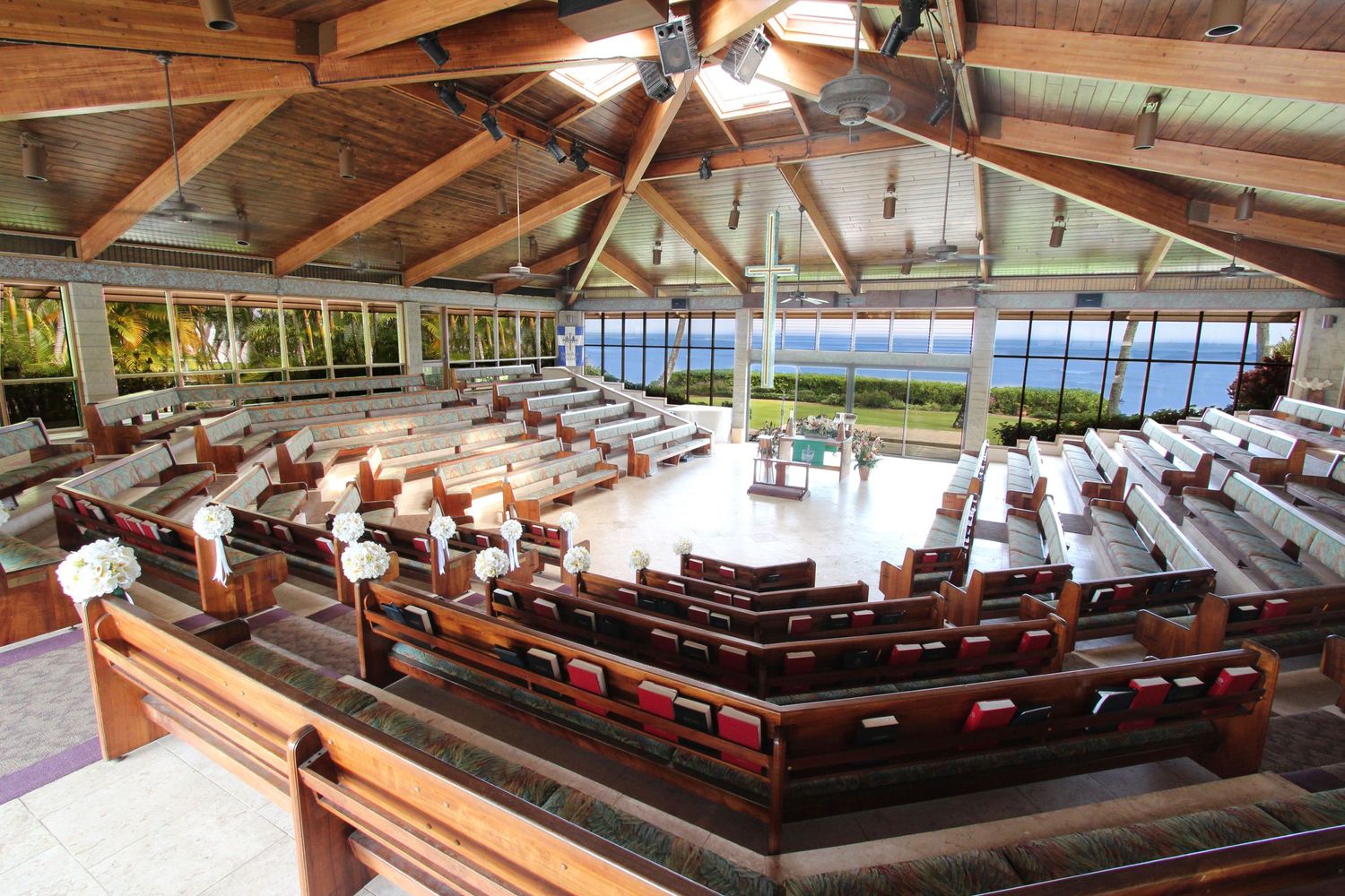Bright open-air chapel interior with wooden pews and panoramic ocean views through large glass windows.
キャルバリーバイザシー教会
ハワイウェディング
ハワイ挙式