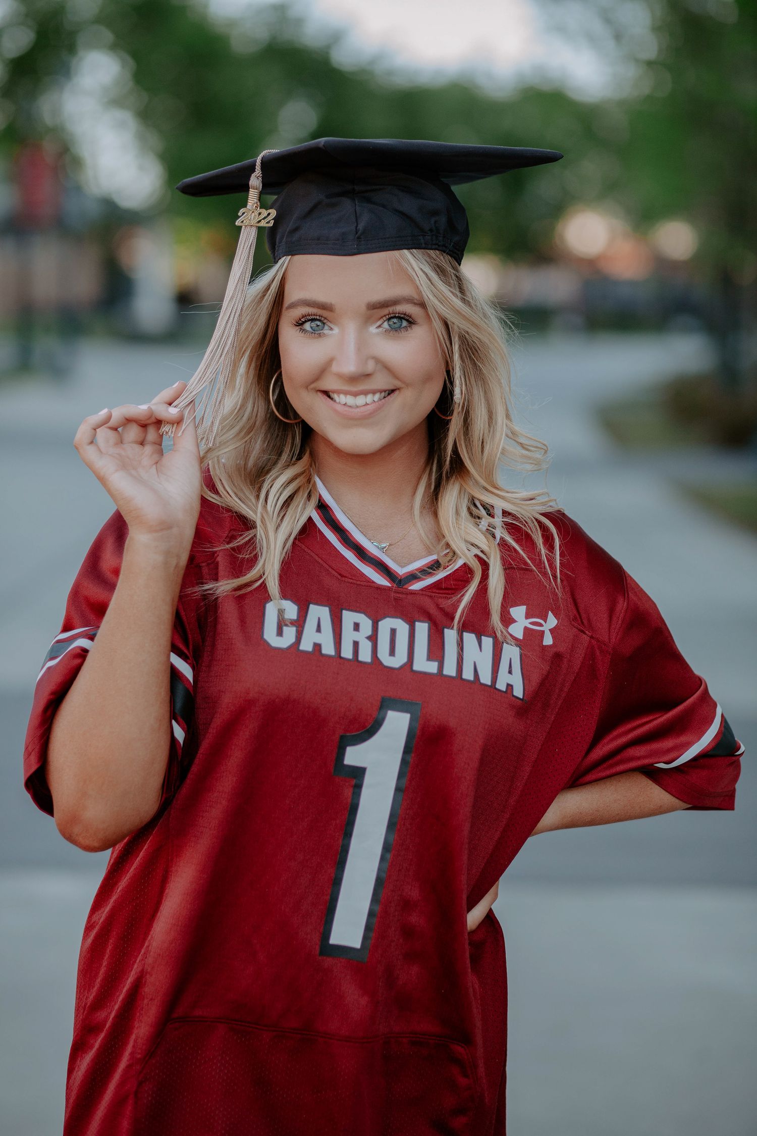 College graduate in a football jersey poses for the camera.