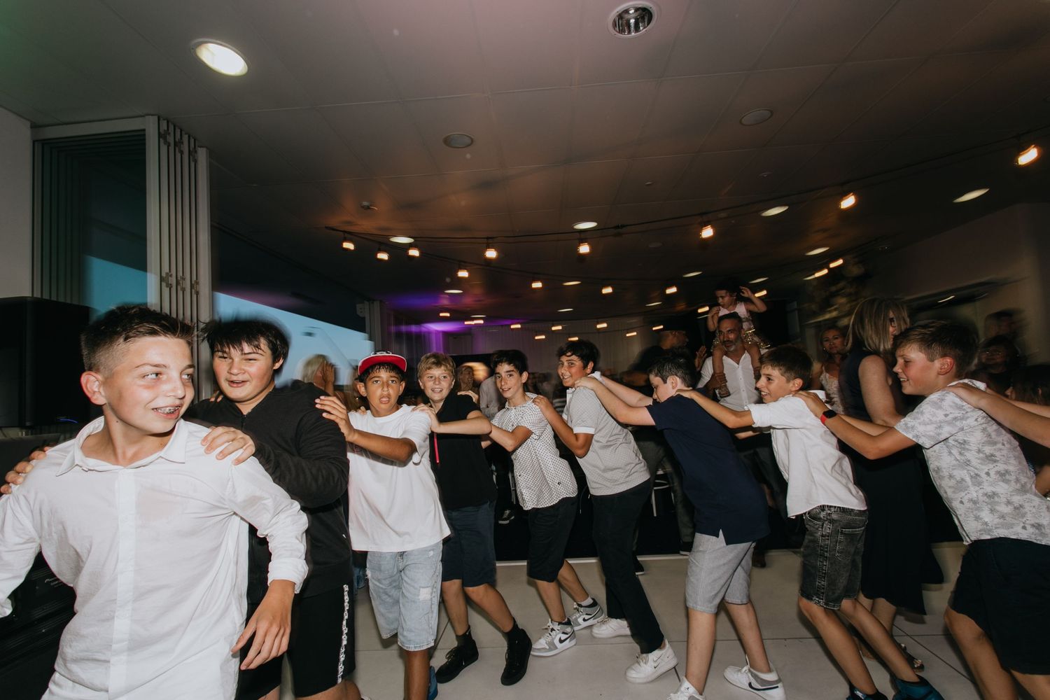 A lively group of boys dance together in a chain at a Bar Mitzvah celebration party.