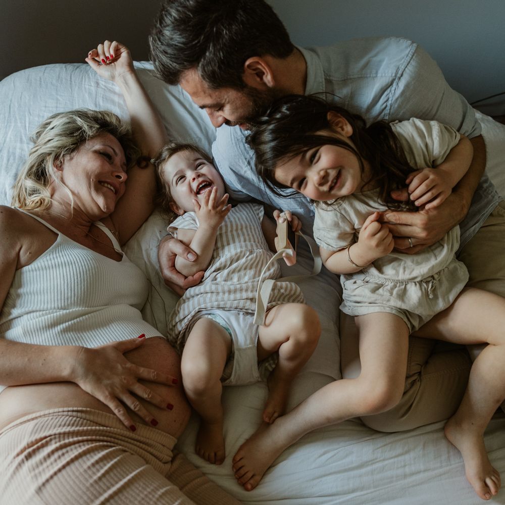 portrait de famille authentique pendant une séance photo grossesse à domicile à Lille