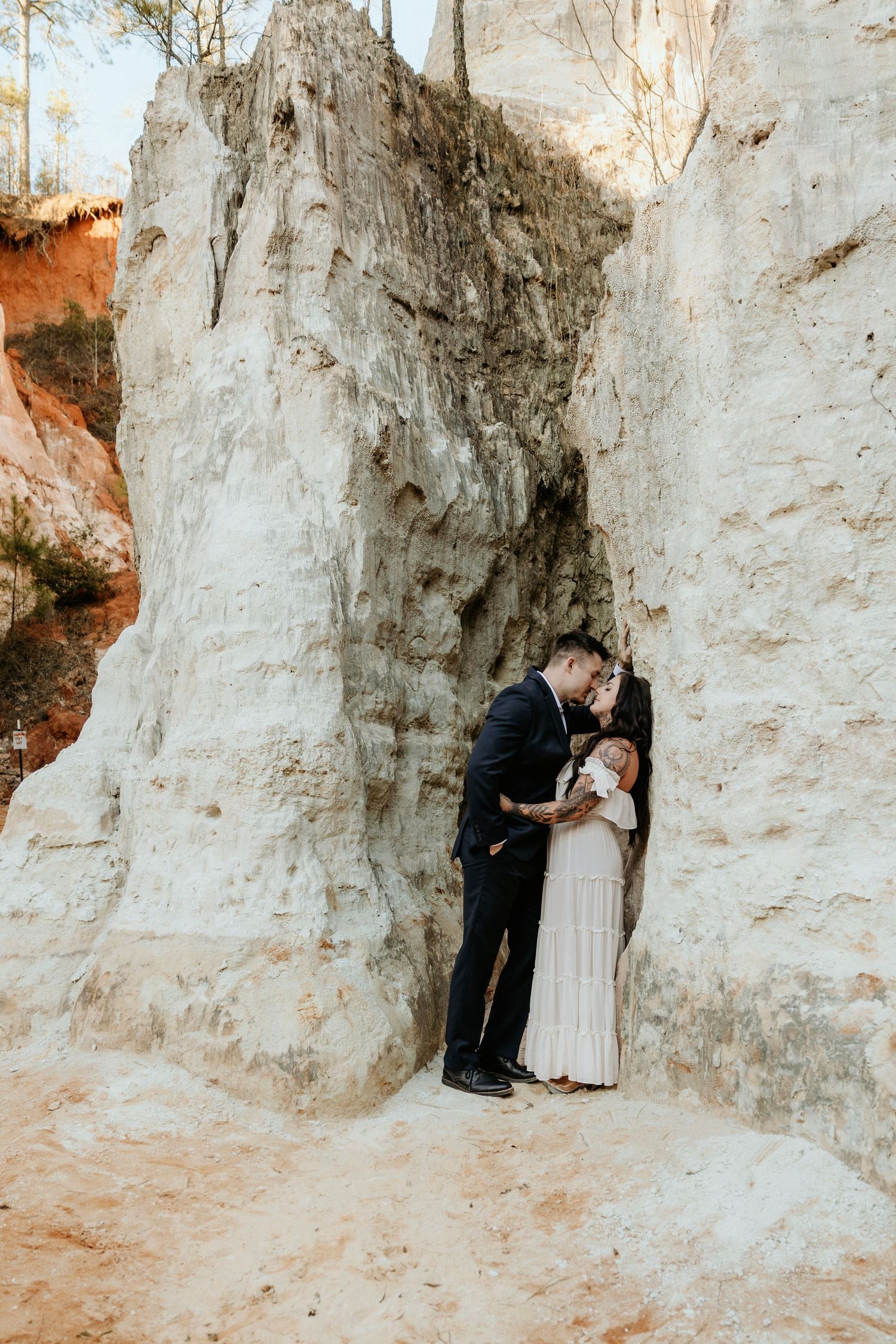 A romantic moment captured between white limestone cliffs in a natural setting.