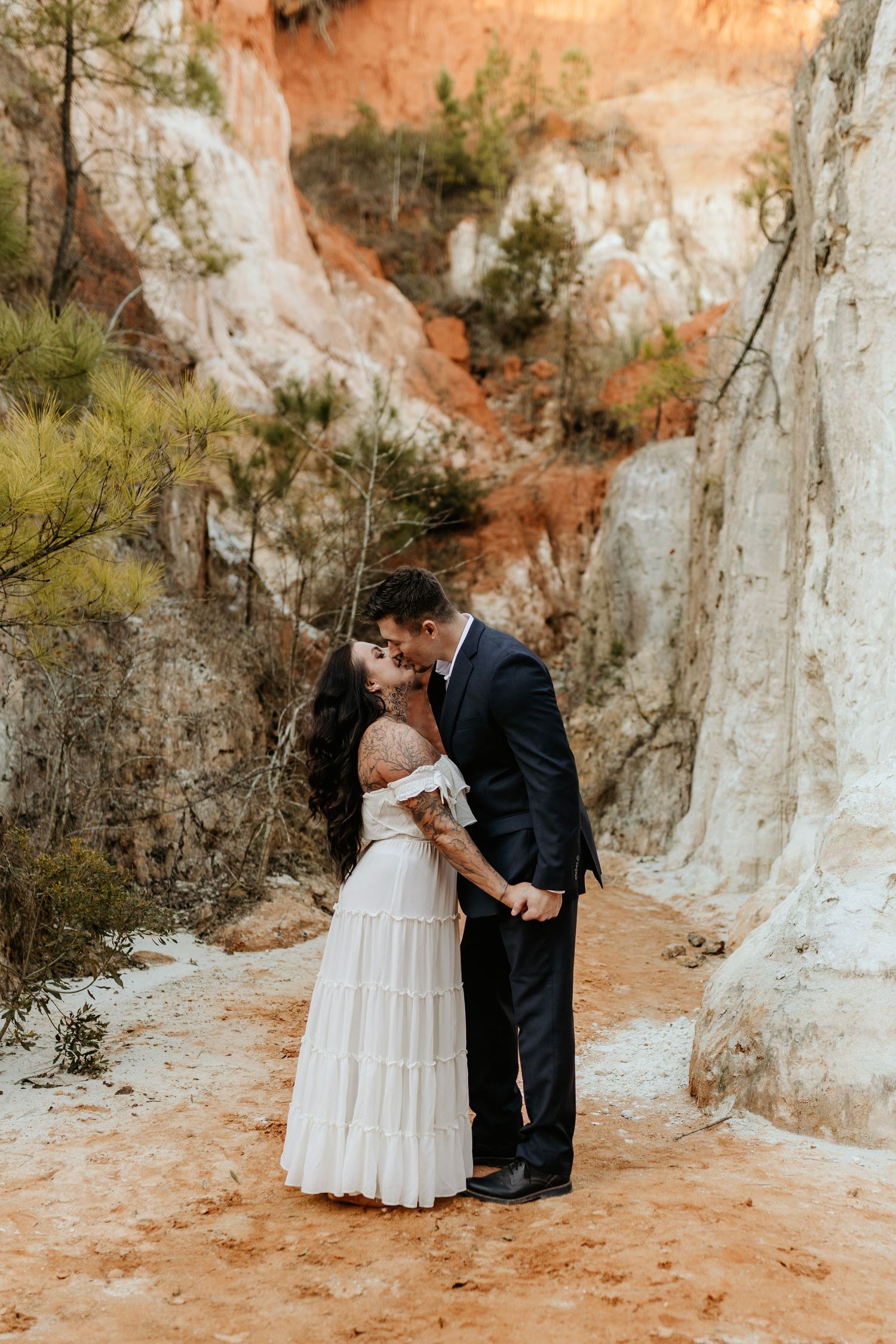 A tender embrace among towering limestone cliffs with orange and white rock formations.