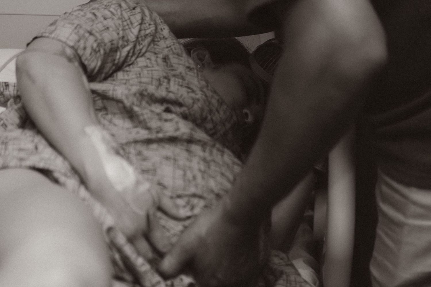 An intimate black and white photograph showing hands tenderly touching.