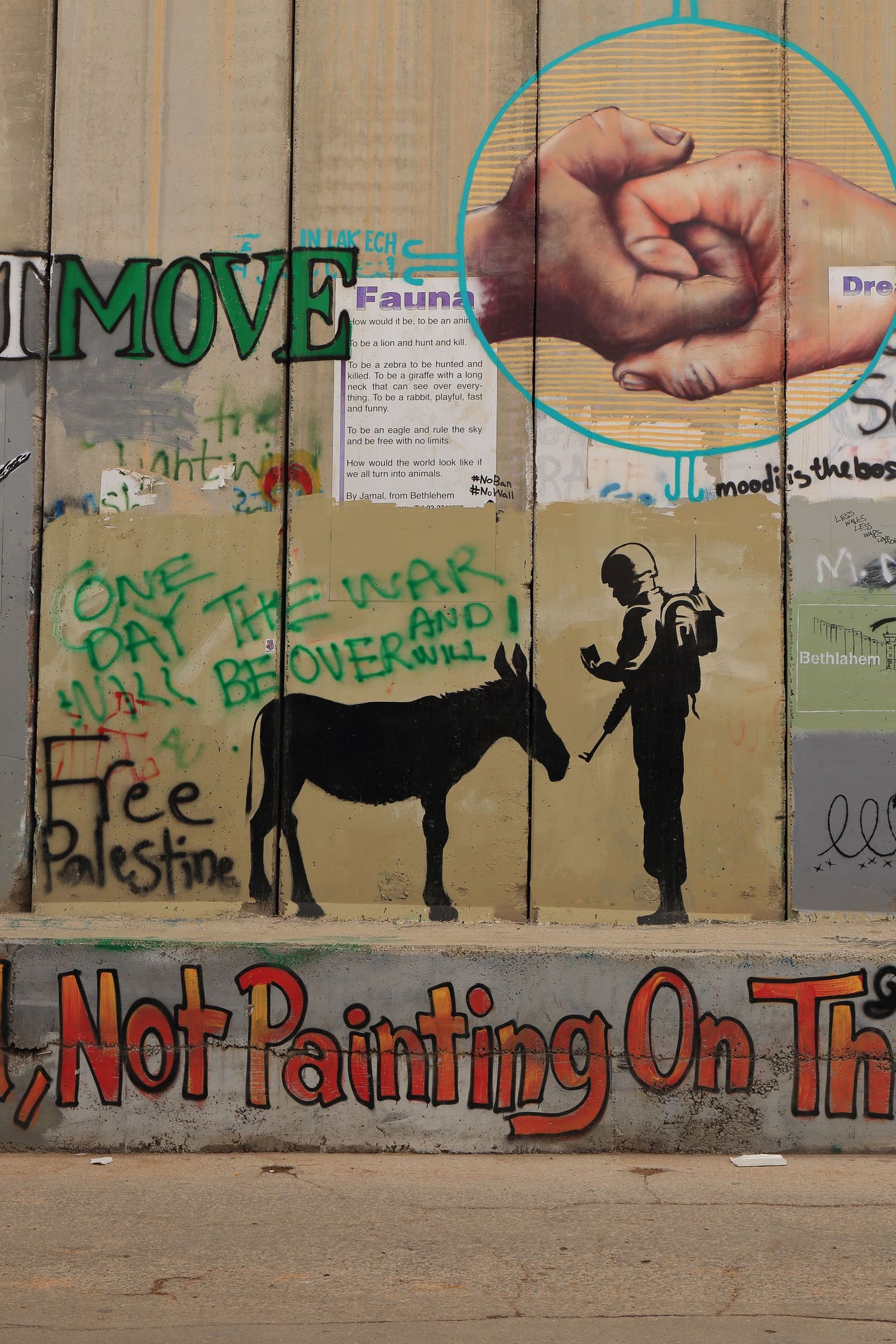 Street art on separation wall shows a donkey being checked by security and protest messages.