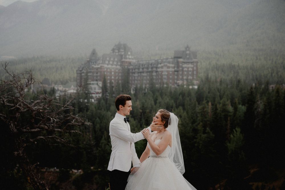Bride and groom embracing on their wedding day with scenic backdrop | Calgary wedding photographer capturing romantic, timeless moments.