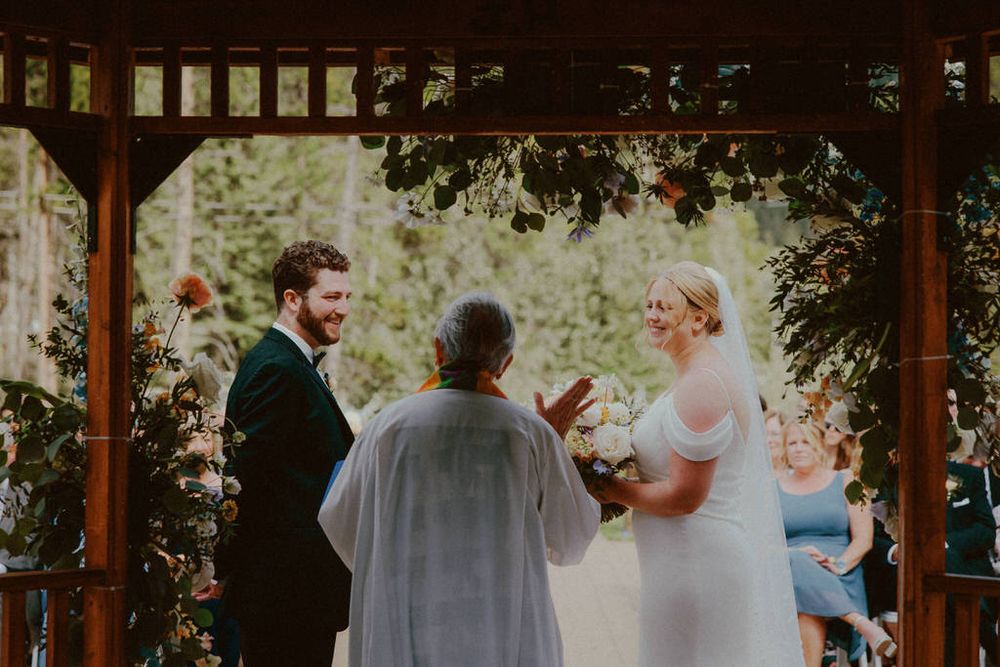 Bride and groom embracing on their wedding day with scenic backdrop | Calgary wedding photographer capturing romantic, timeless moments.