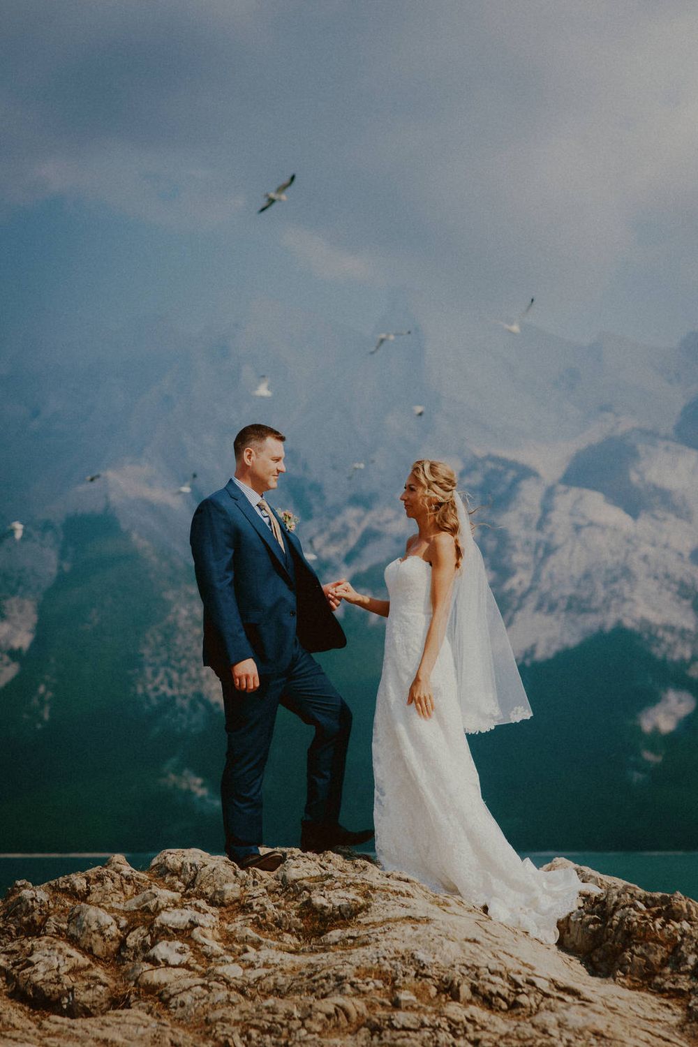 Bride and groom embracing on their wedding day with scenic backdrop | Calgary wedding photographer capturing romantic, timeless moments.