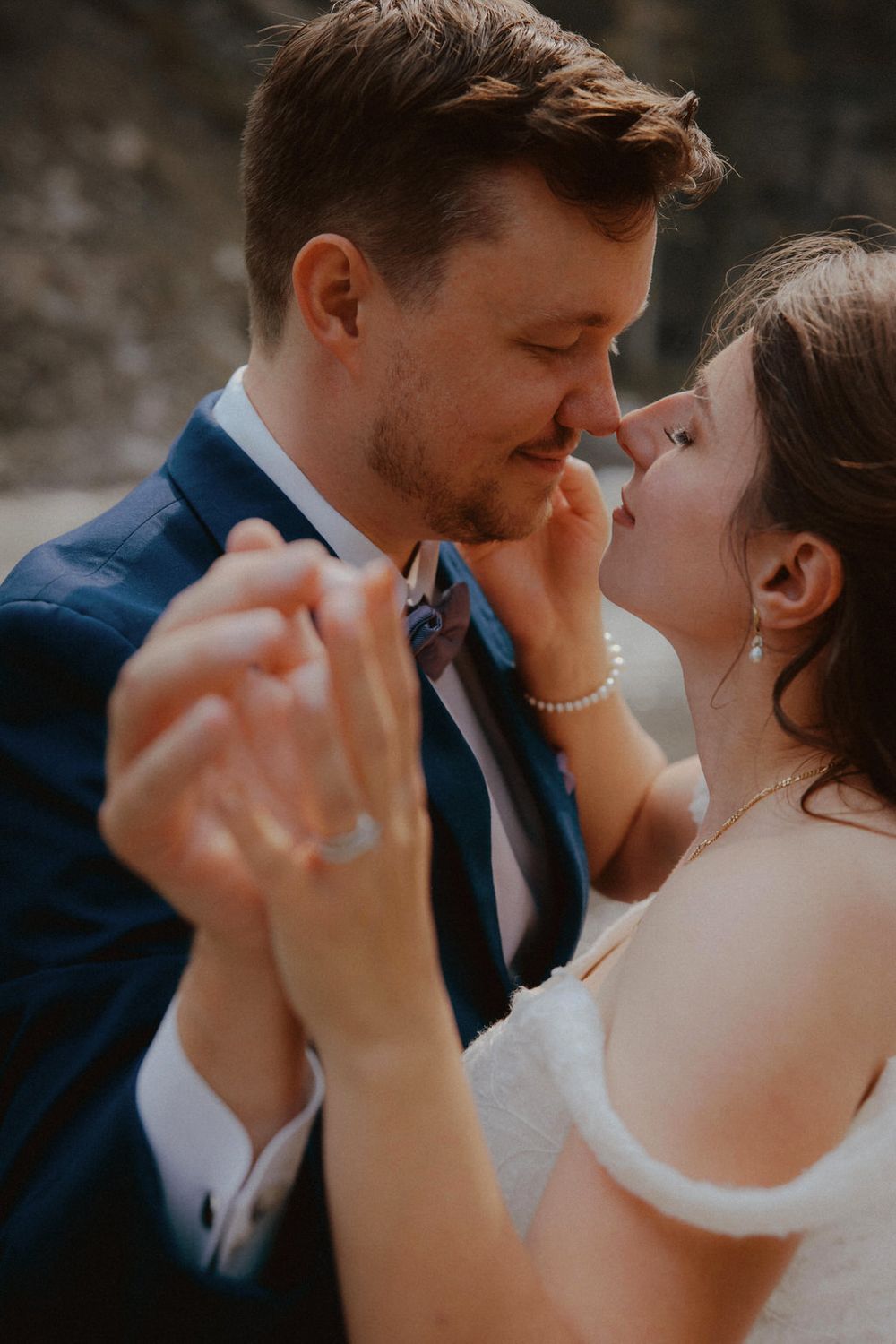 Bride and groom embracing on their wedding day with scenic backdrop | Calgary wedding photographer capturing romantic, timeless moments.
