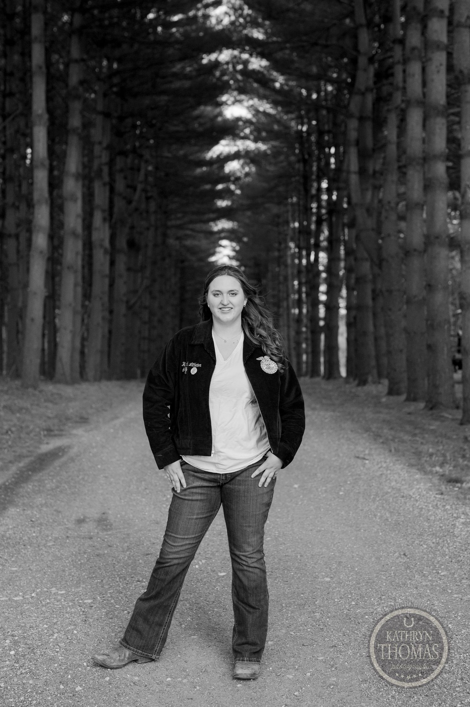 A black and white portrait on a tree-lined path wearing FFA attire.