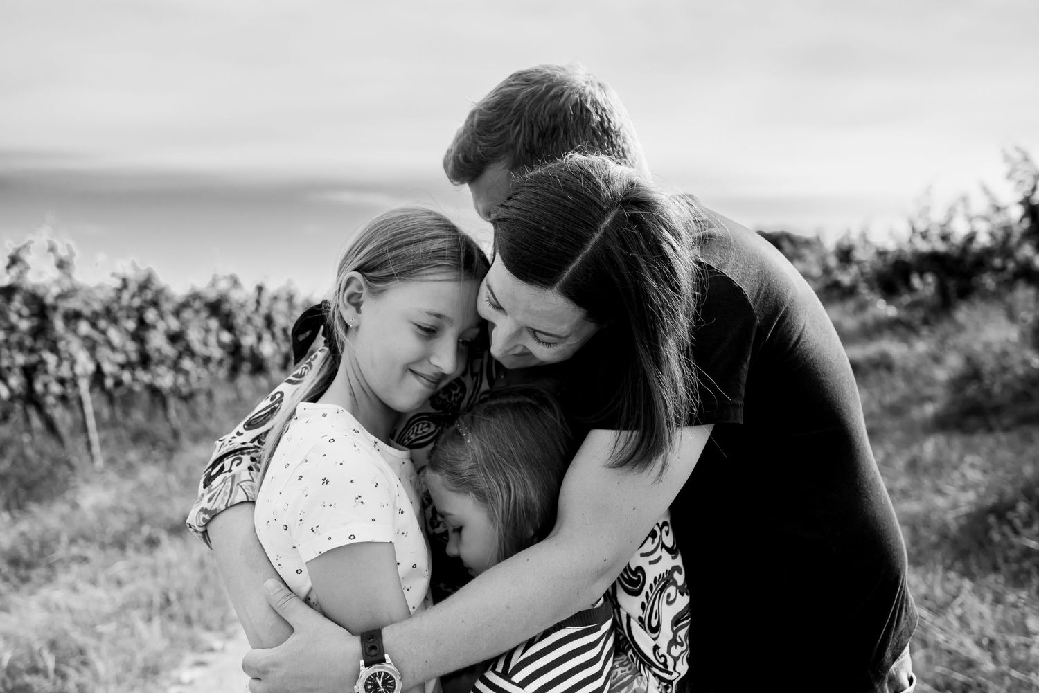 Family embracing in lovely hug in the vineyards in Nyon, Switzerland