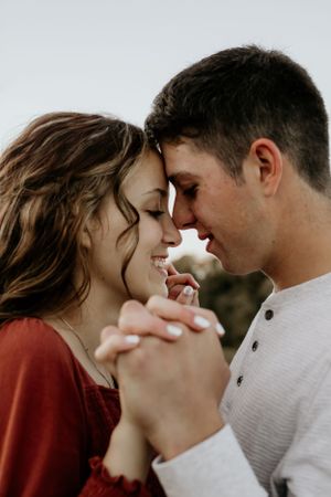 Intimate close-up of couple sharing tender moment outdoors.