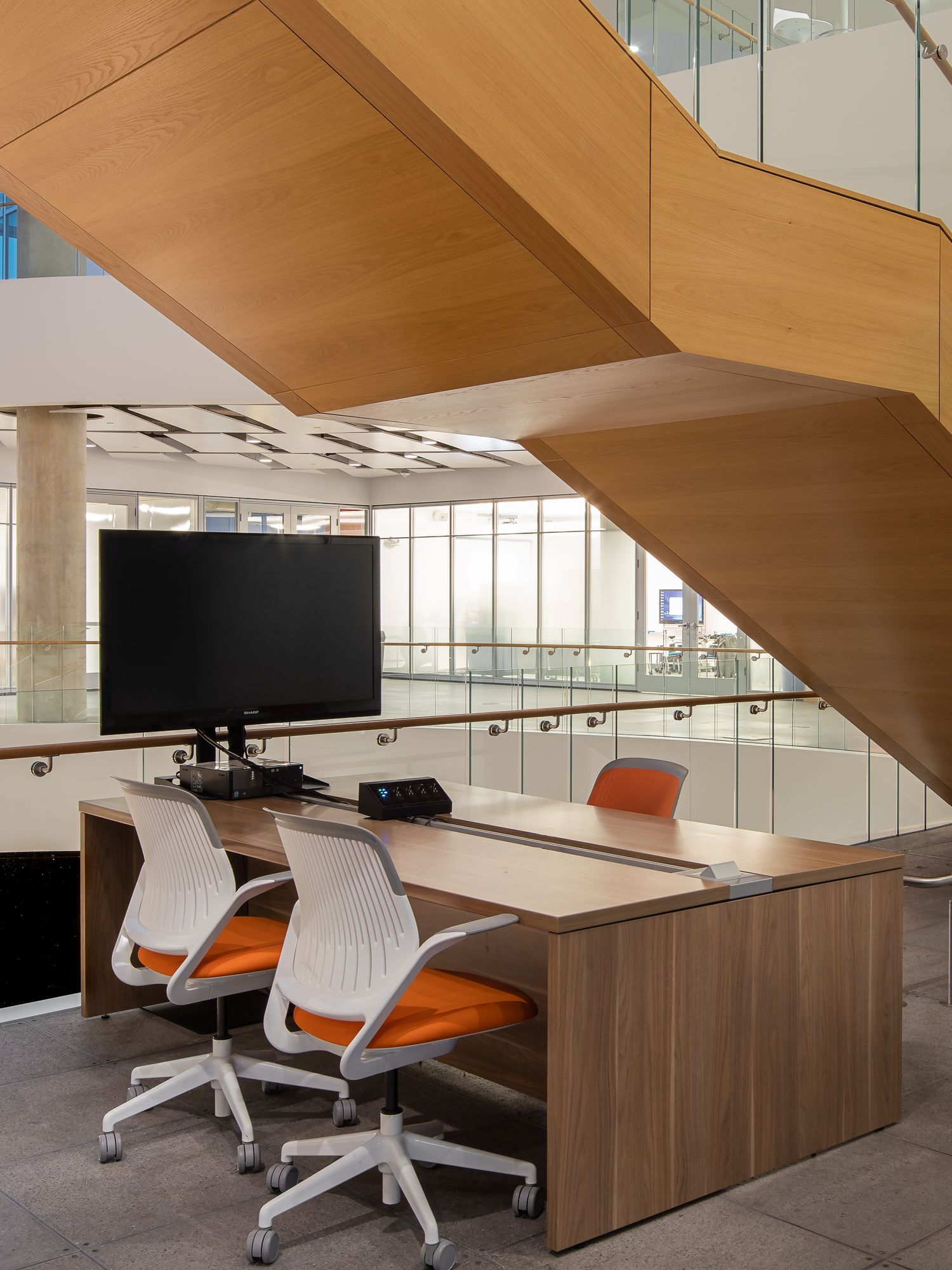 Orange and white chairs at a desk in a commercial office building.