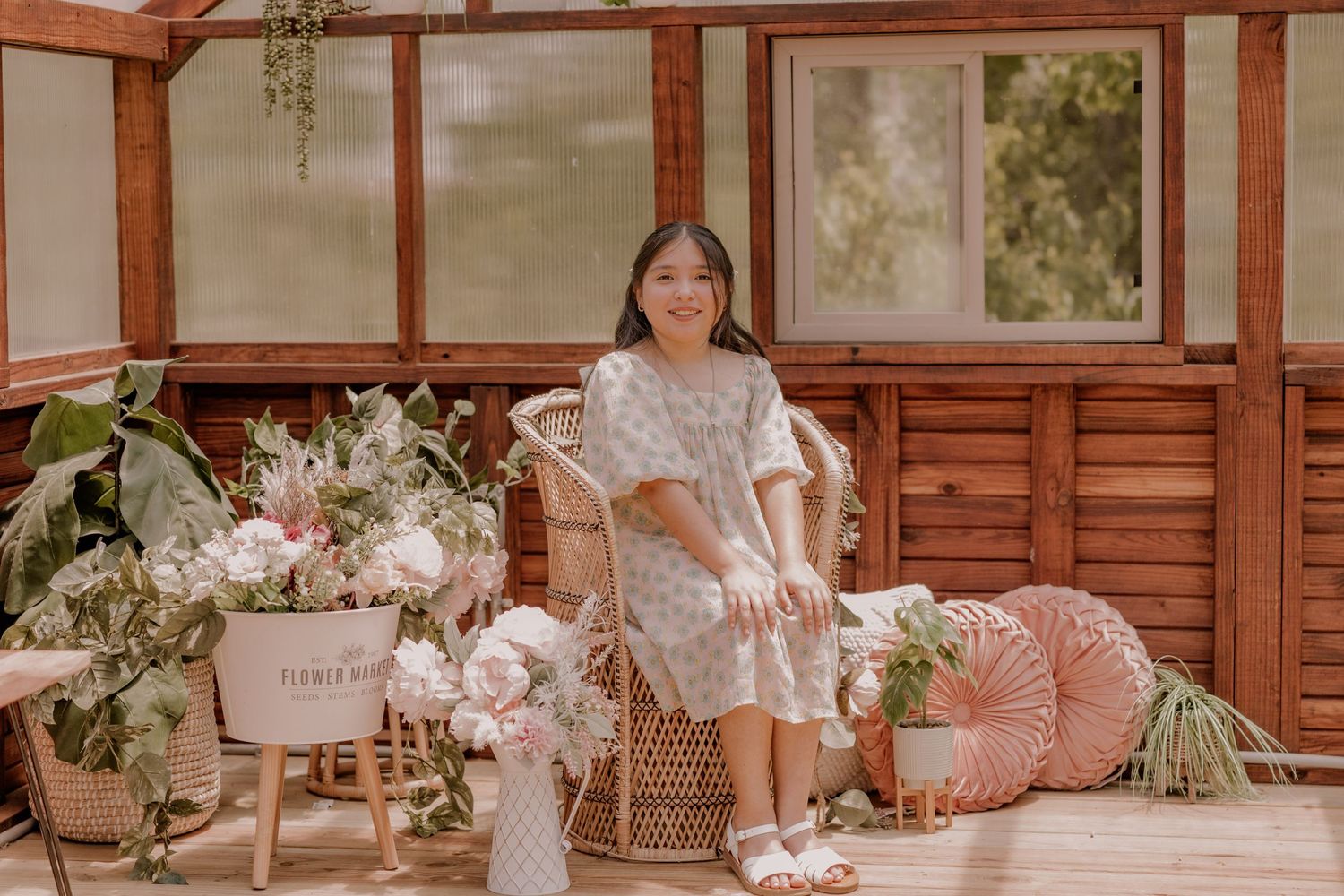 Elegant floral-decorated sunroom with wooden paneling, cushioned seating, and pink accents.