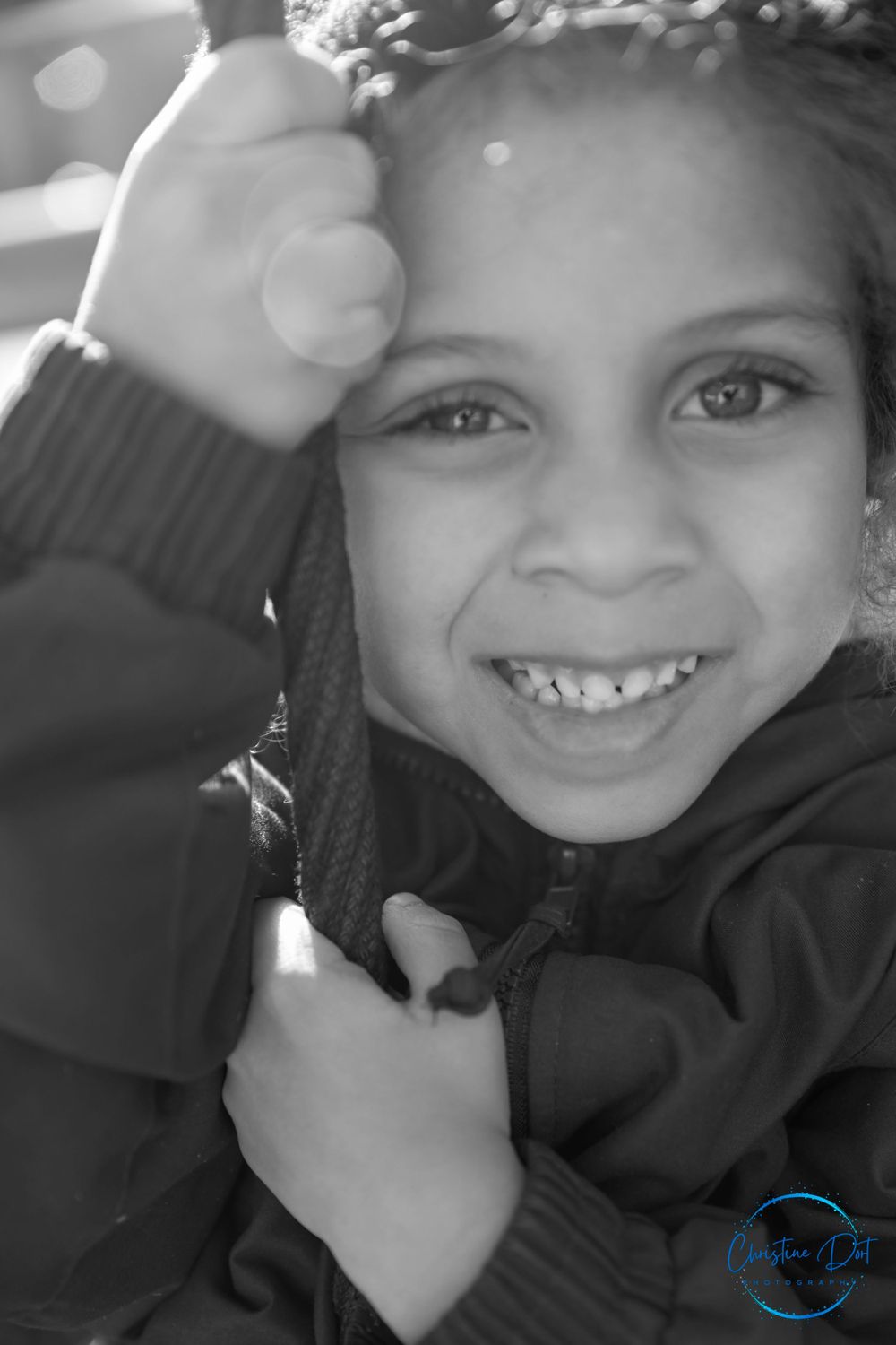 Black and white candid portrait capturing joyful laughter in winter clothing.