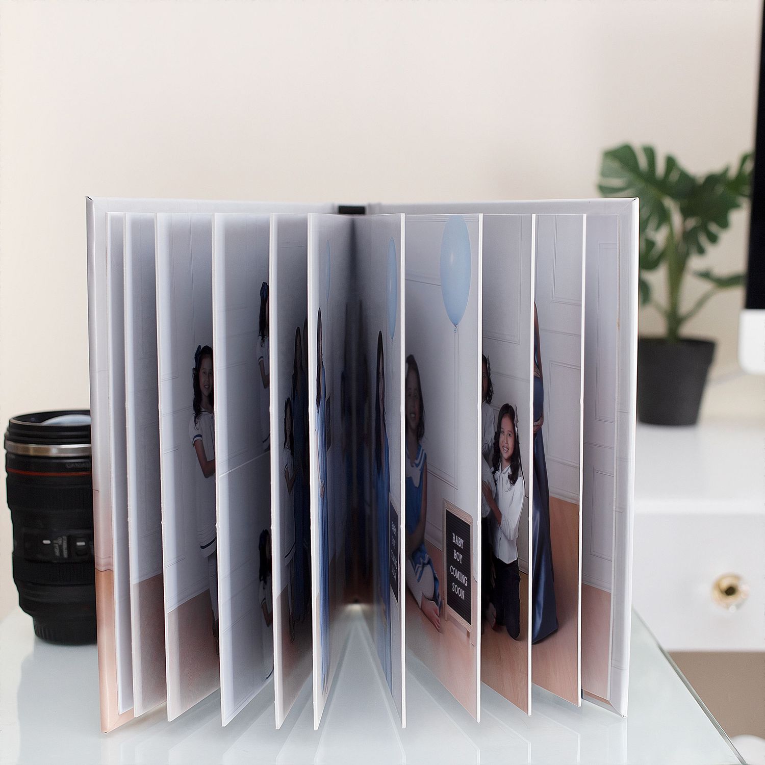 Professional photo album showing cascading pages with family portraits arranged in an artistic style.