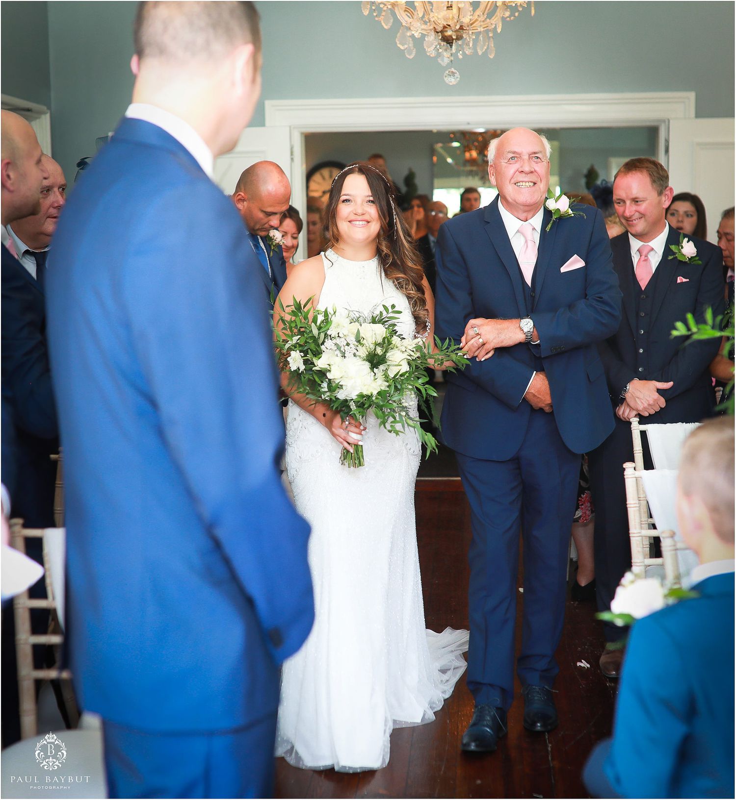 Wedding ceremony processional in bright indoor venue with classic decor.