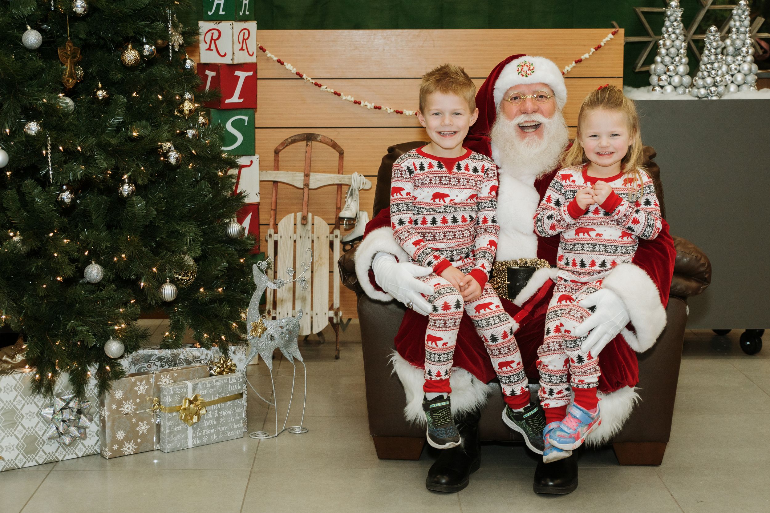 A festive Christmas scene with matching holiday pajamas and decorated tree.