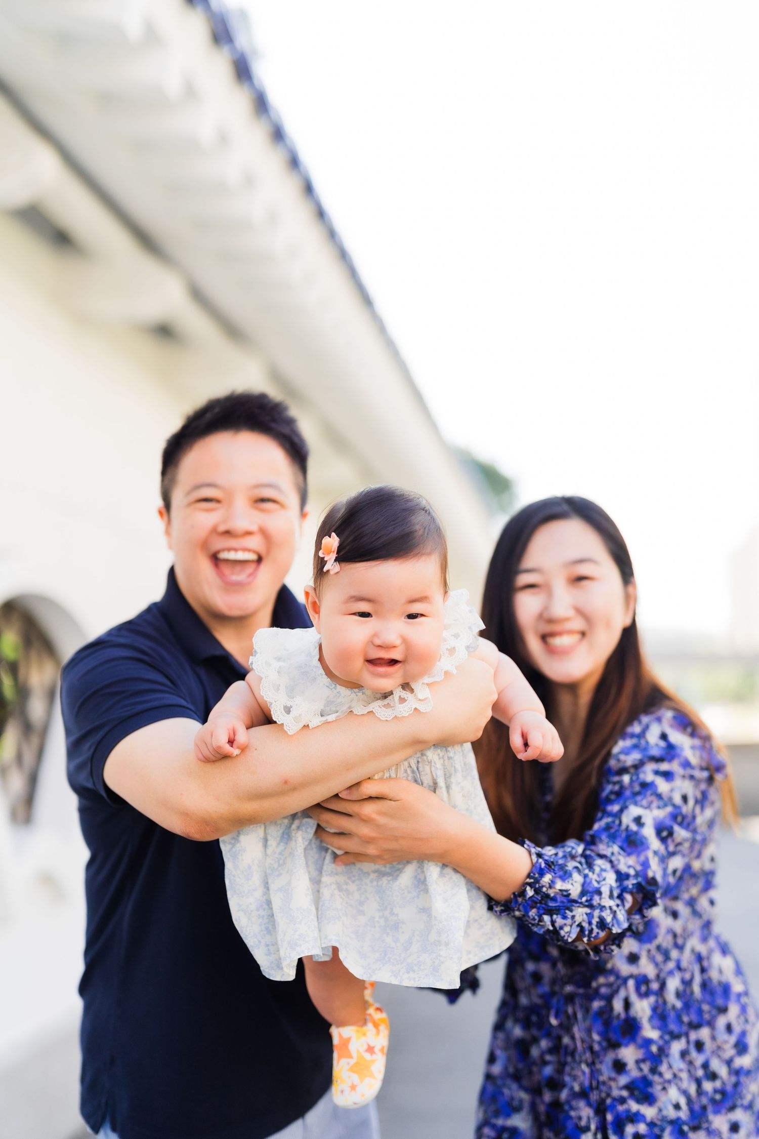 A family shares a joyful moment outdoors on a bright sunny day.