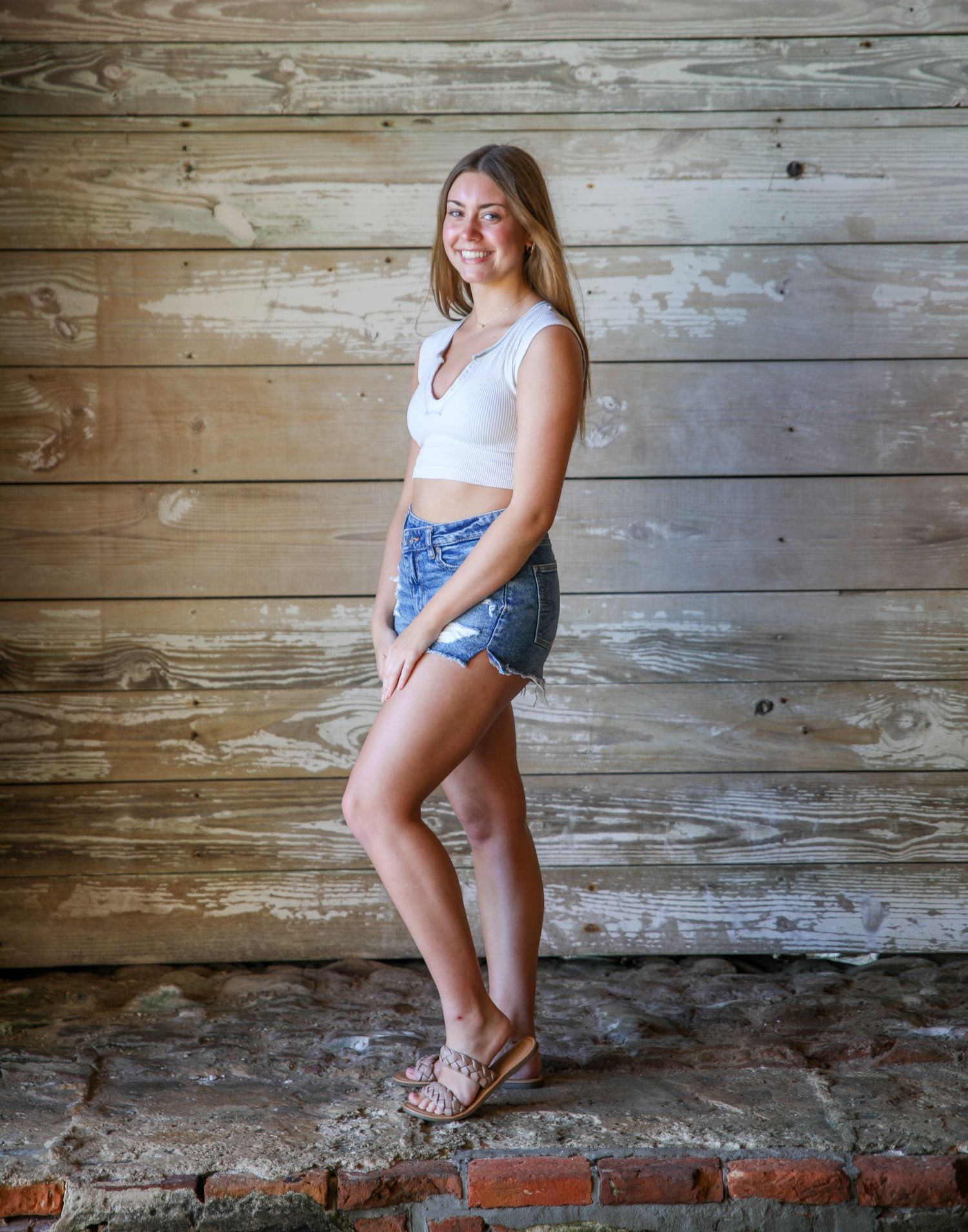 Summer fashion portrait against weathered wooden wall background.