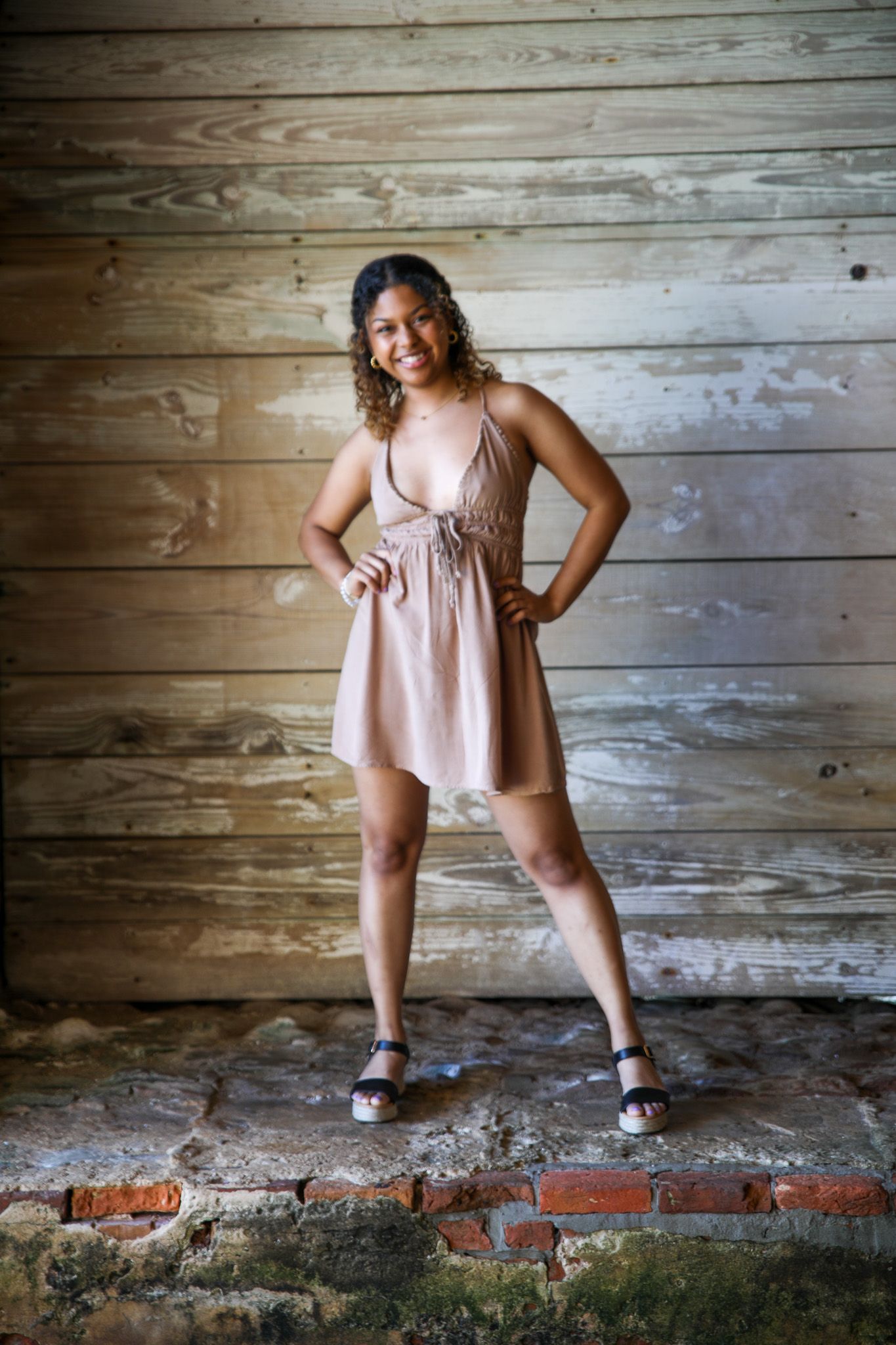 Portrait in pink dress against rustic wooden wall background.
