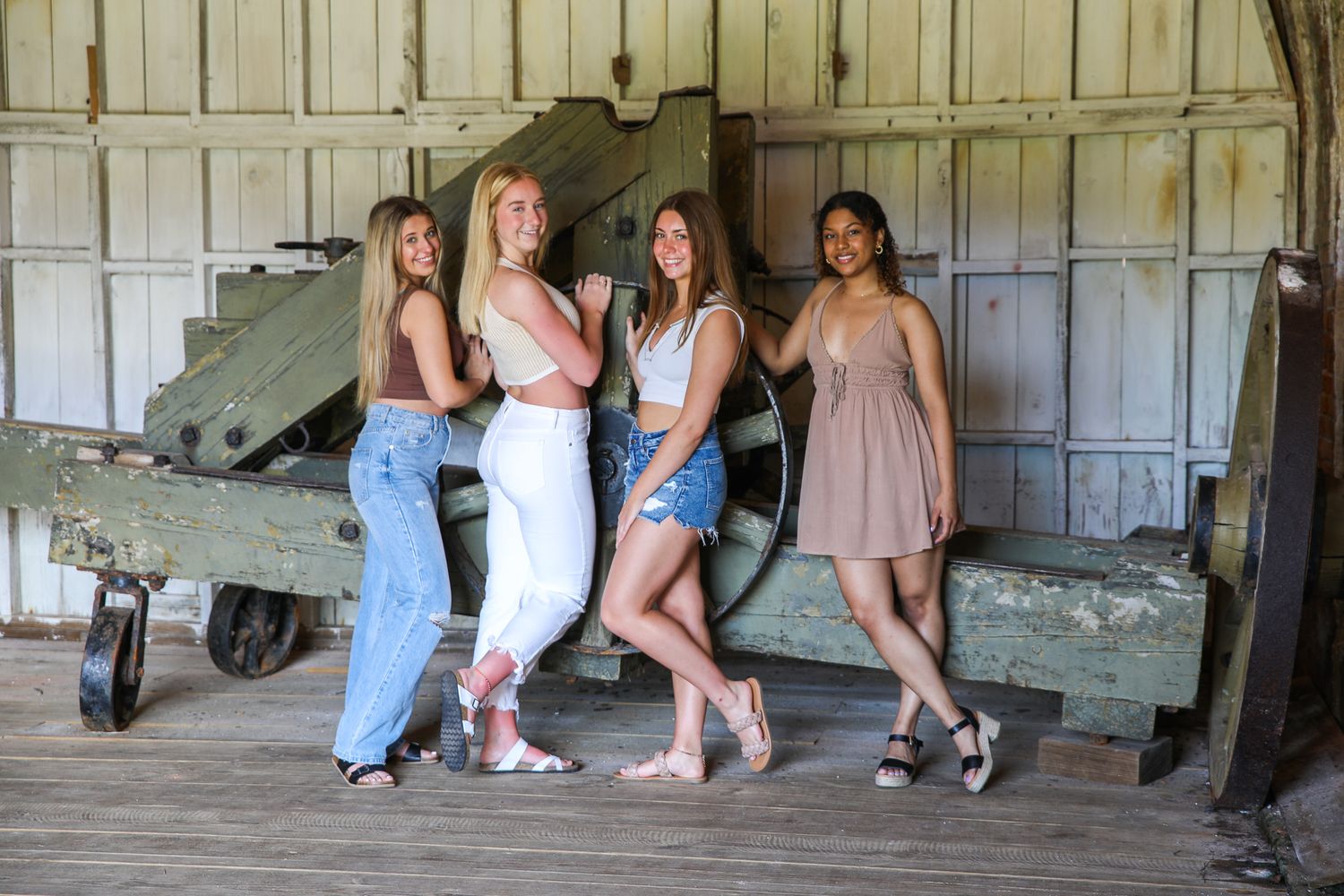 Group in casual outfits poses together near vintage machinery.